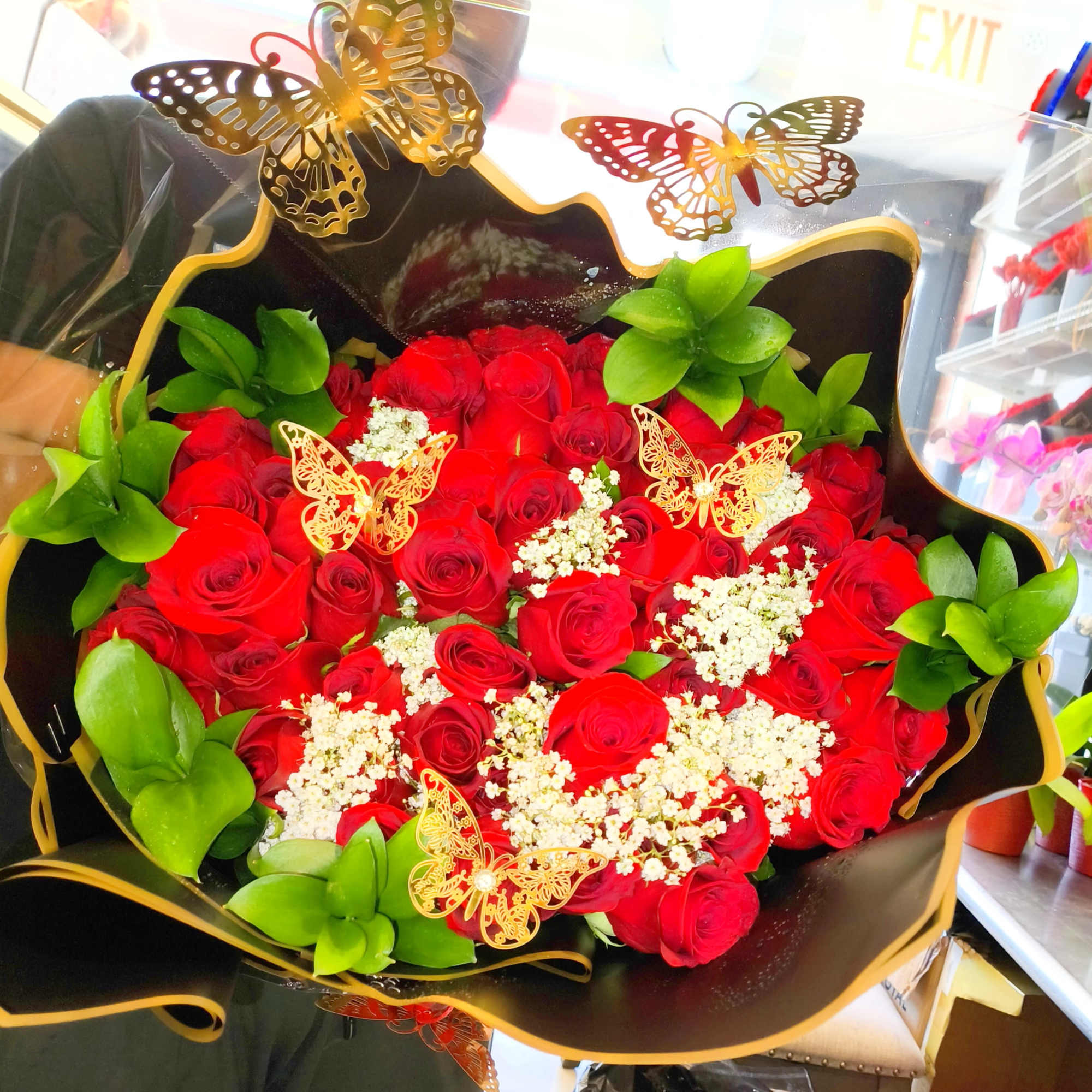 Bouquet of red roses with white filler and green accents