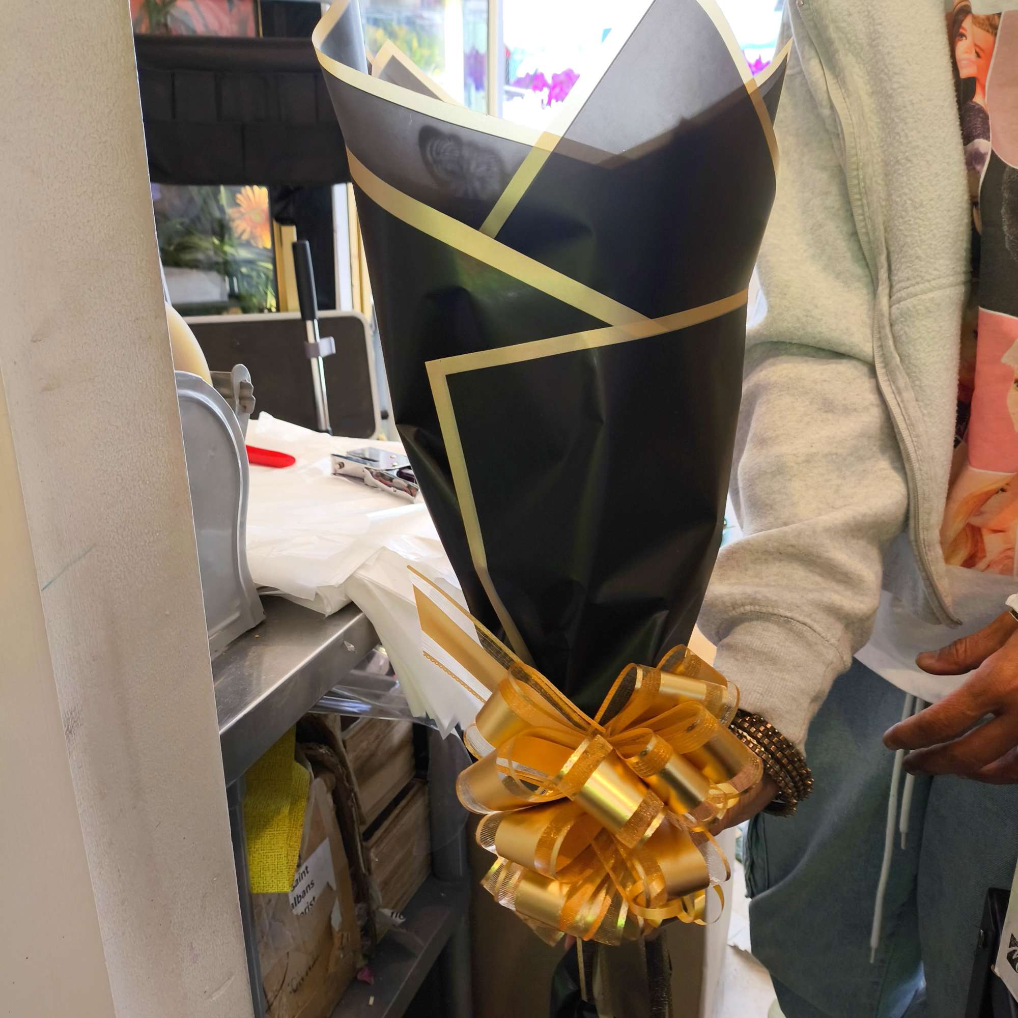 Wrapped bouquet with a gold ribbon bow