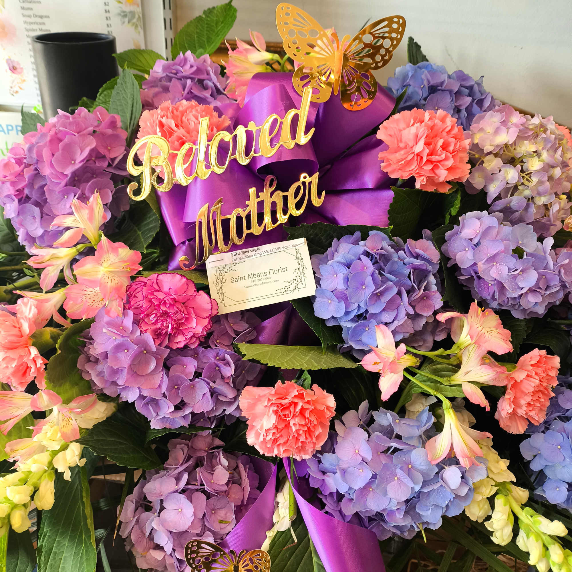 Bouquet of purple hydrangeas and pink carnations with a purple ribbon