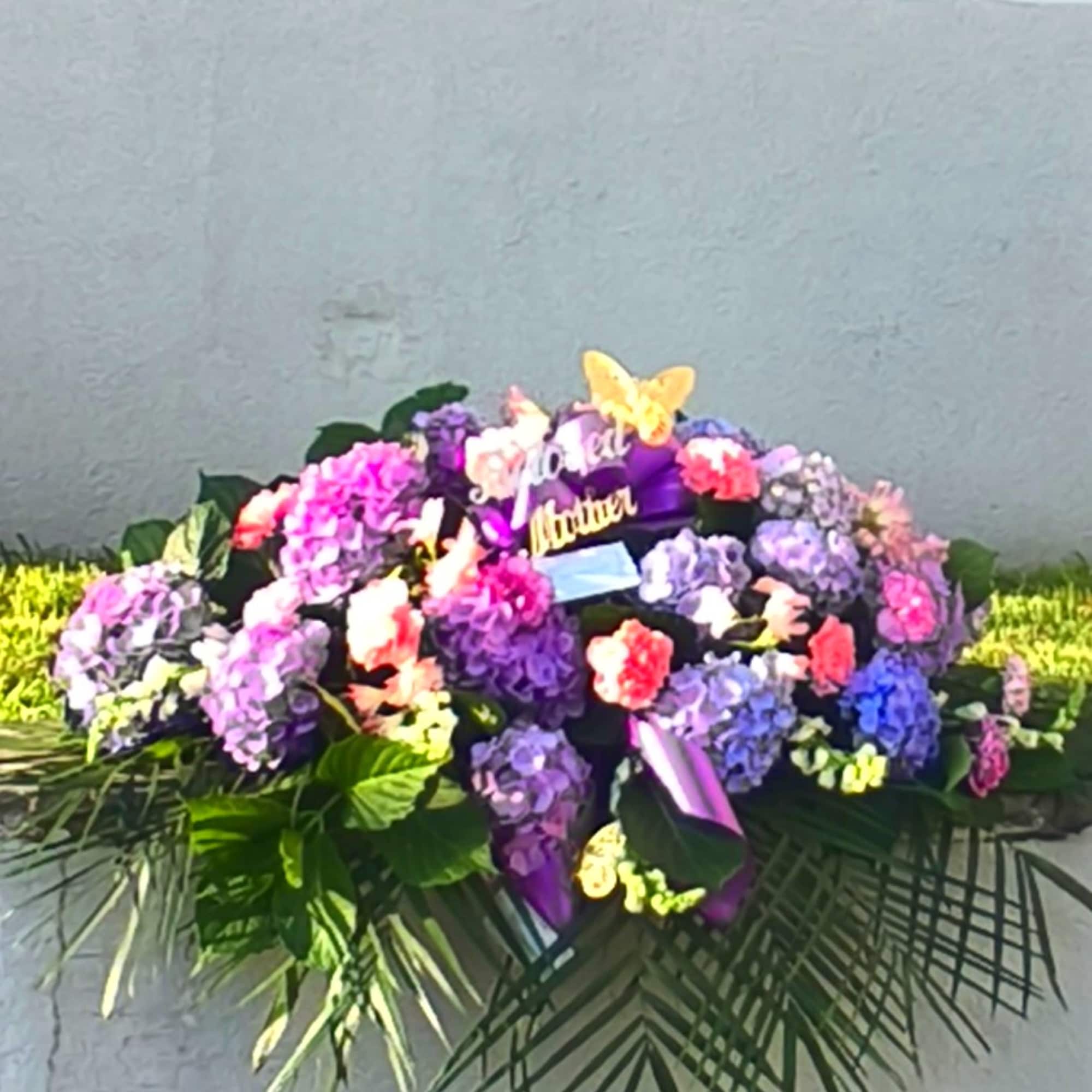 Large purple and pink floral spray with a butterfly accent