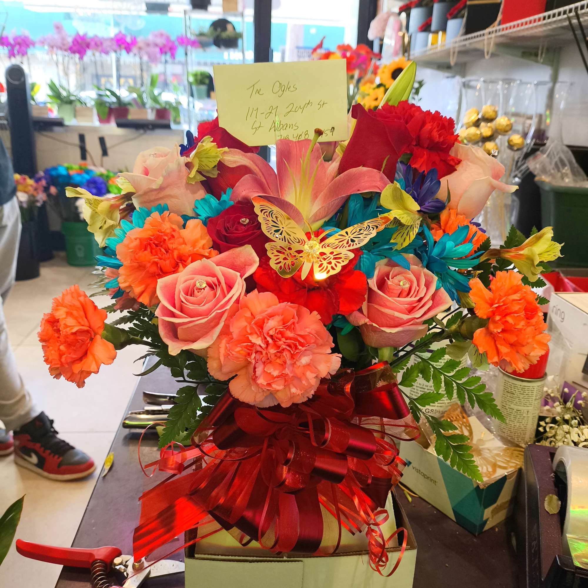 Bright mixed bouquet with roses, lilies, and carnations in a gift box