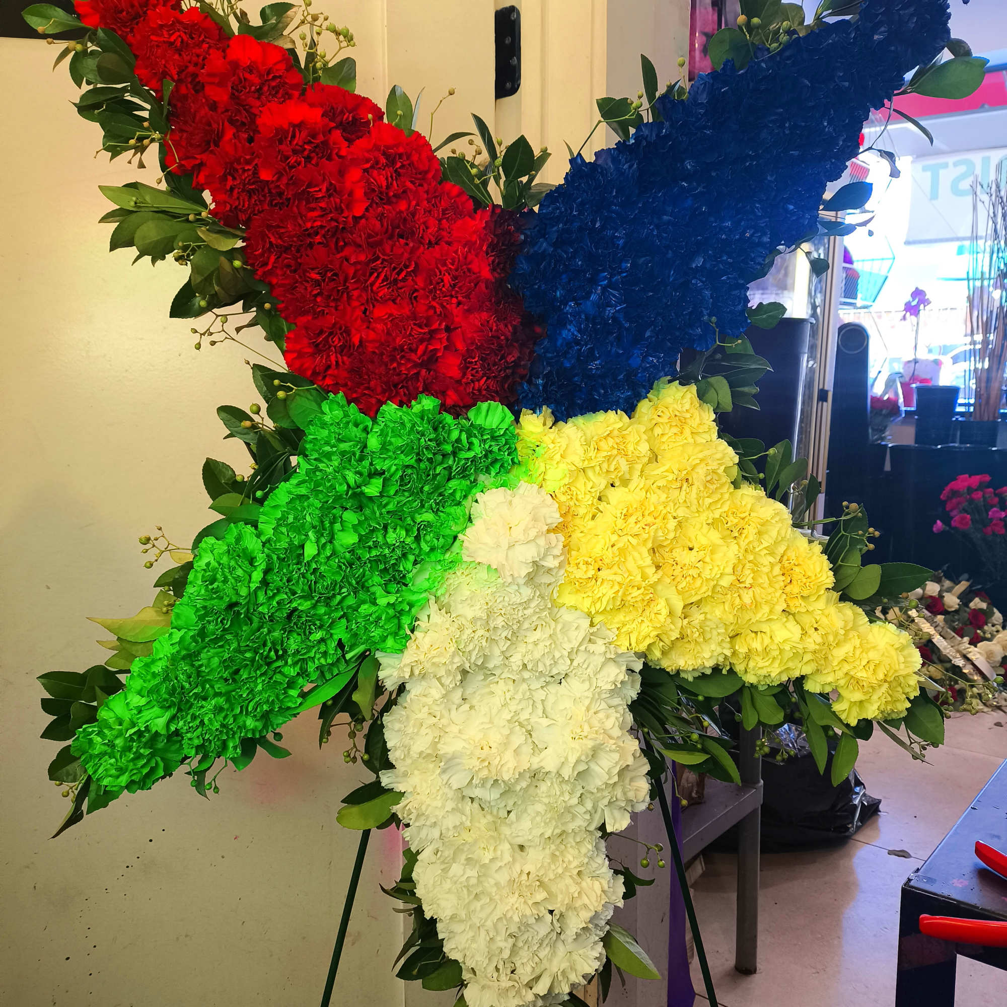 Large five-point floral tribute in red, blue, green, yellow, and white