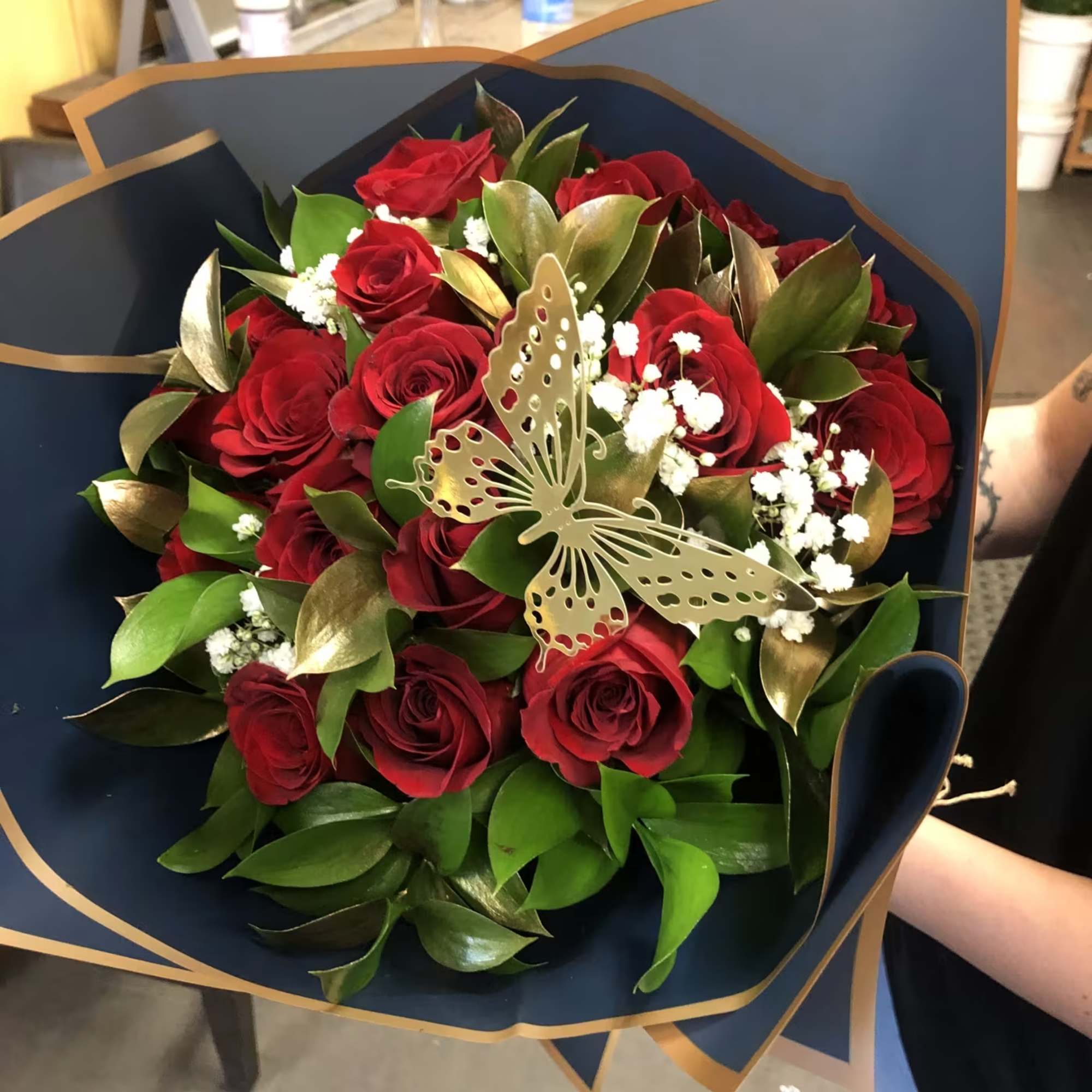 Bouquet of red roses with white baby's breath and a butterfly decoration