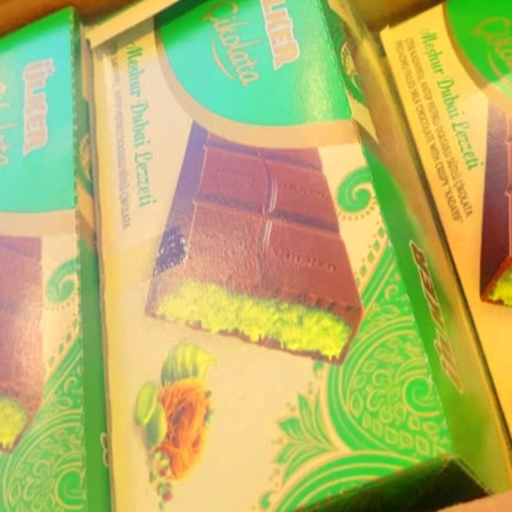Stacked green and cream product boxes in a cardboard carton