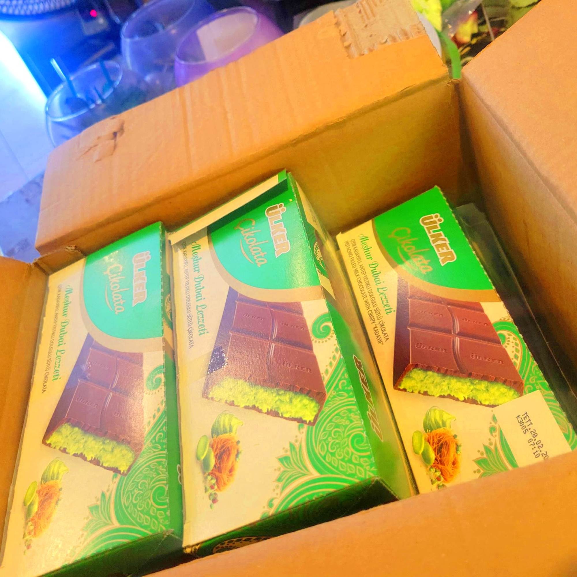 Open cardboard box holding three chocolate bar packages