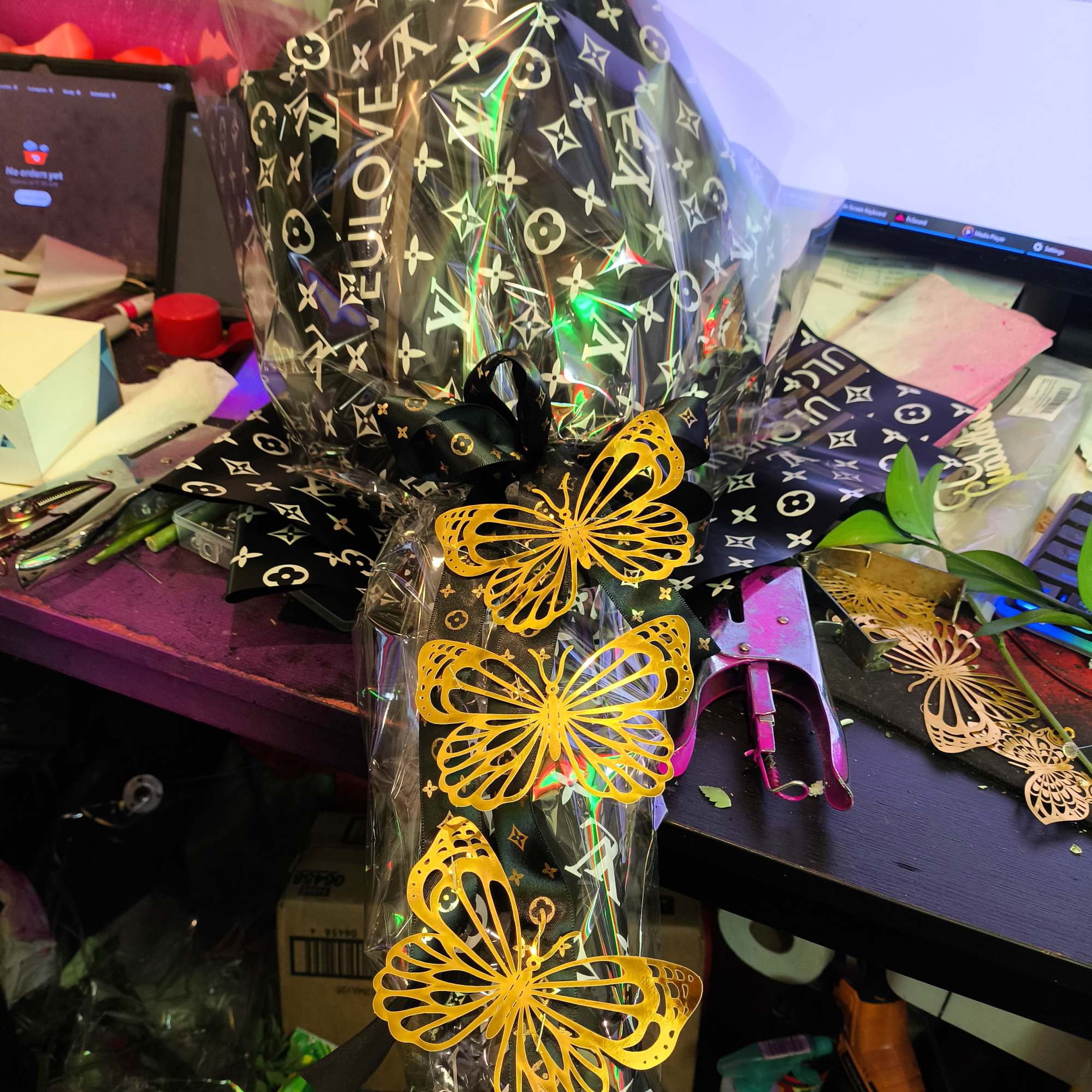 Wrapped gift bundle with black patterned paper and yellow butterfly decorations