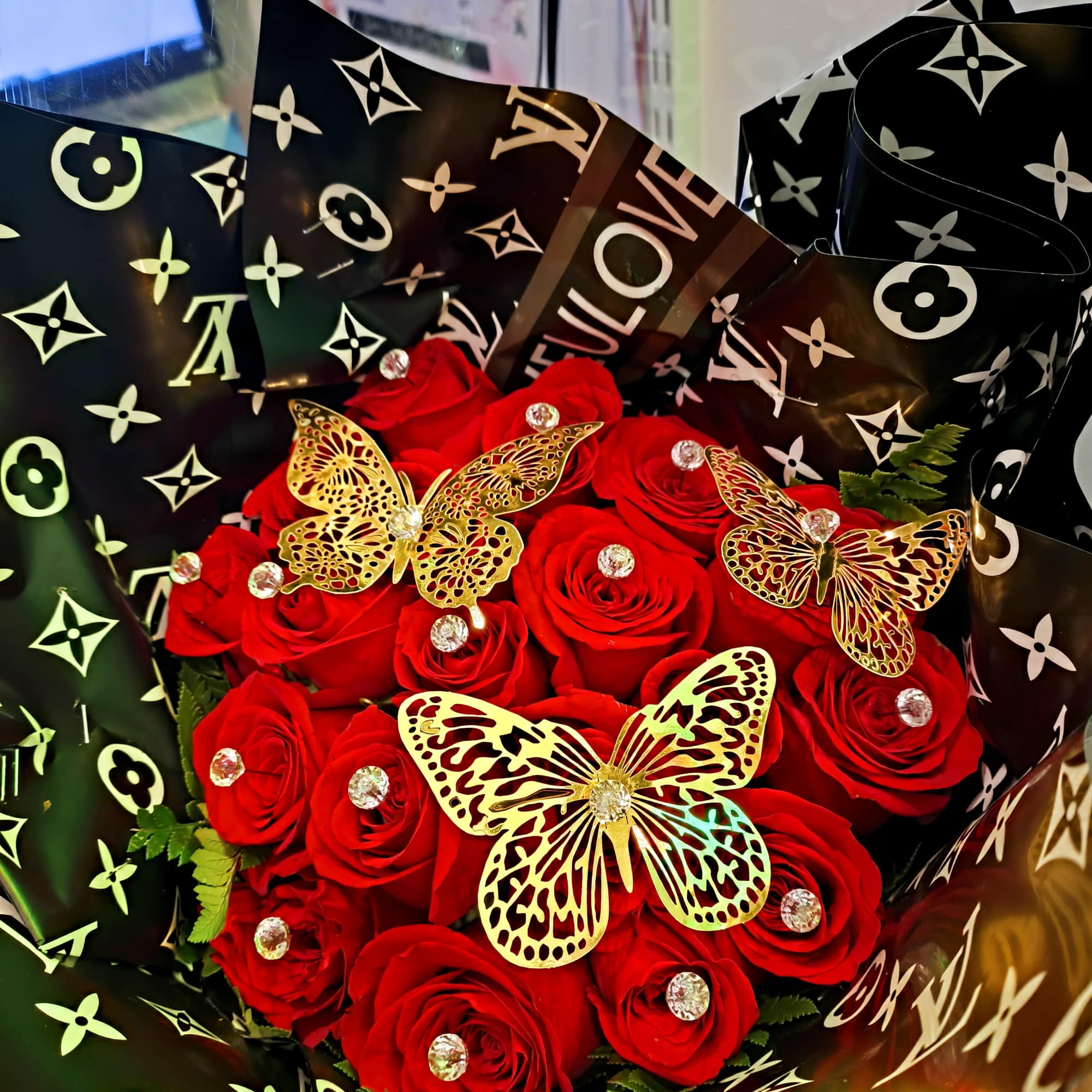 Designer wrapping with 18 red roses and gold butterflies and diamonds with