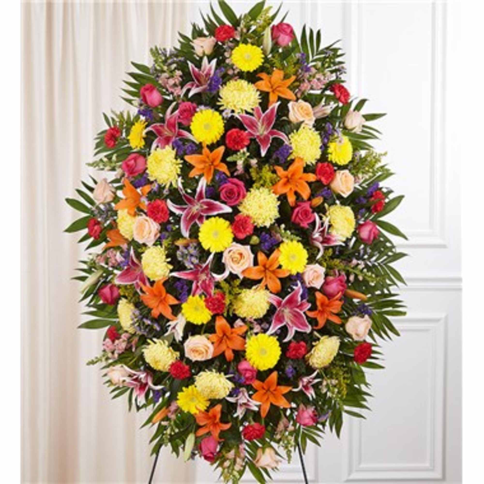 Large standing floral spray with mixed bright flowers on an easel