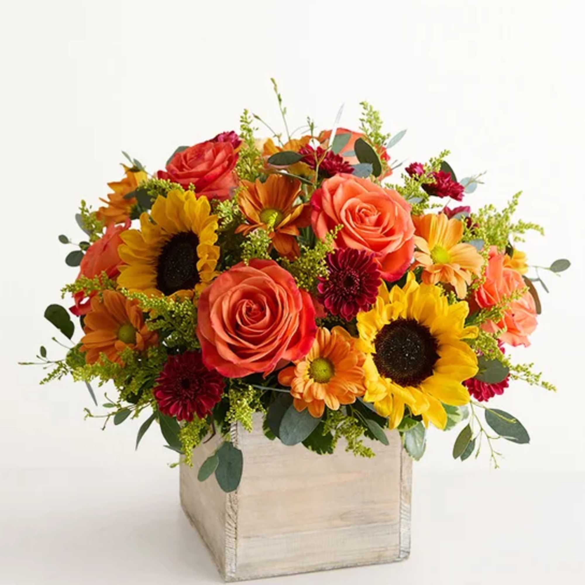 Mixed bouquet of roses and sunflowers in a wooden box