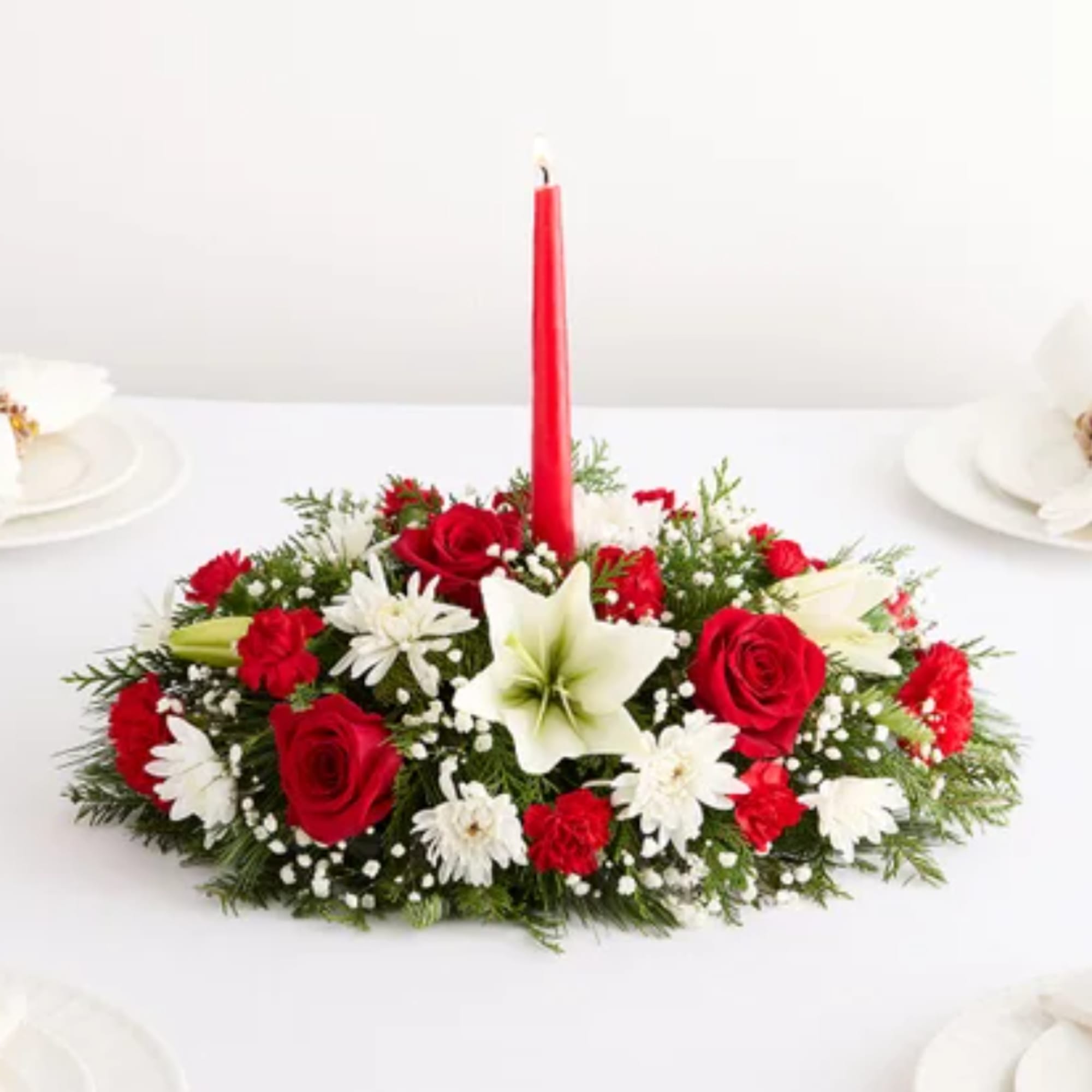 Red and white floral centerpiece with a tall red candle
