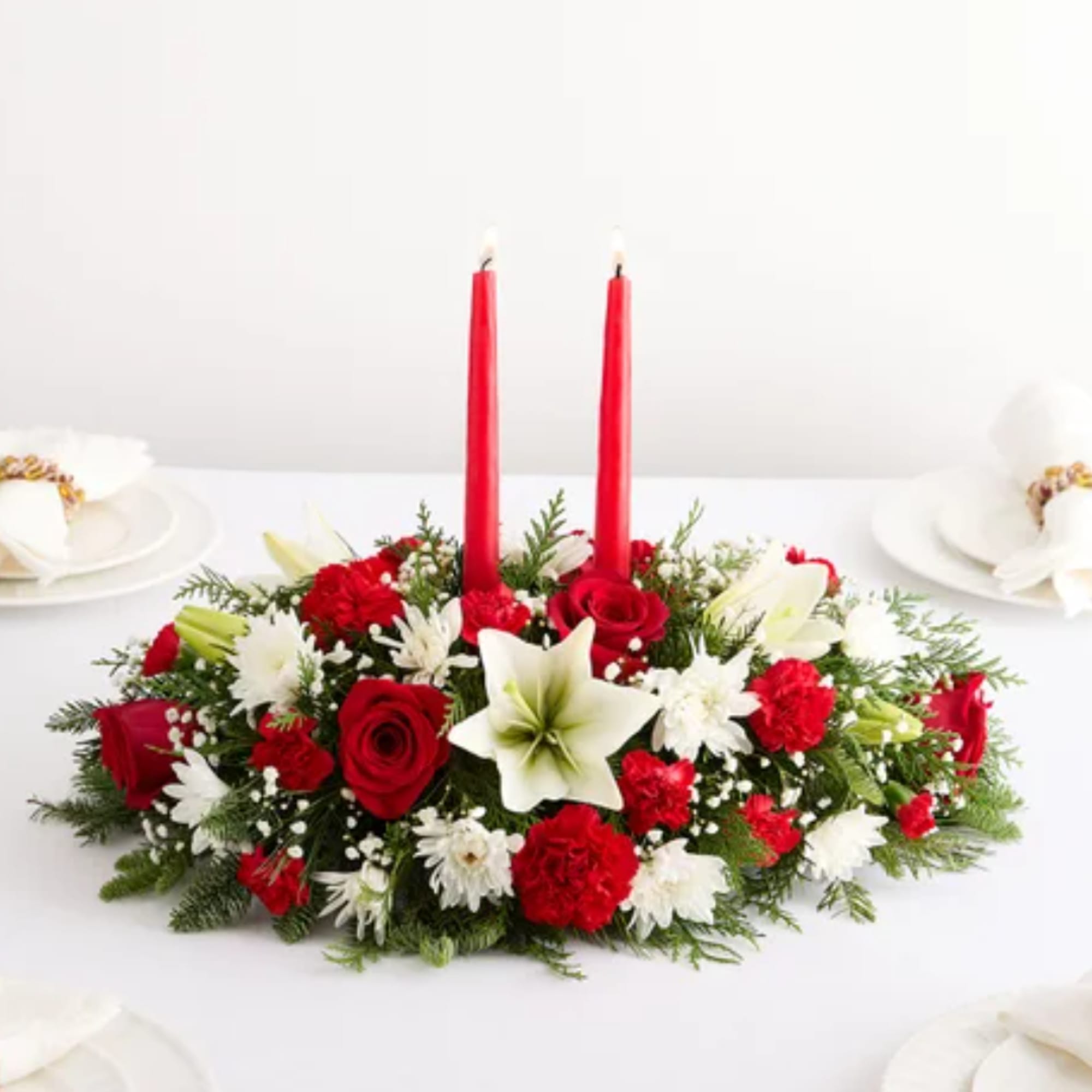 Red and white floral centerpiece with two red candles
