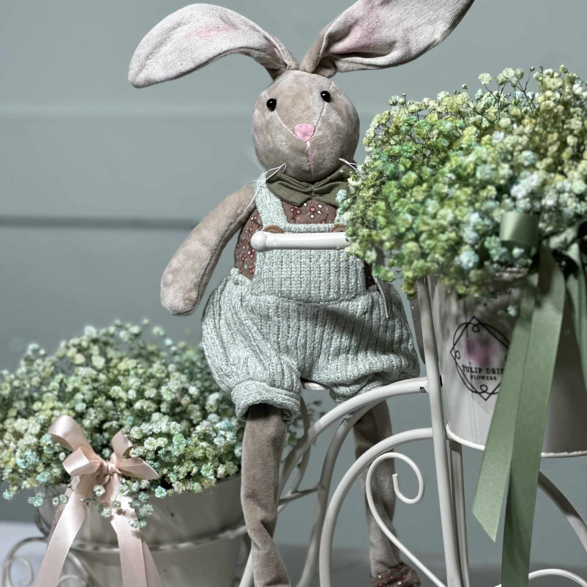 Plush bunny beside two pastel baby’s breath arrangements