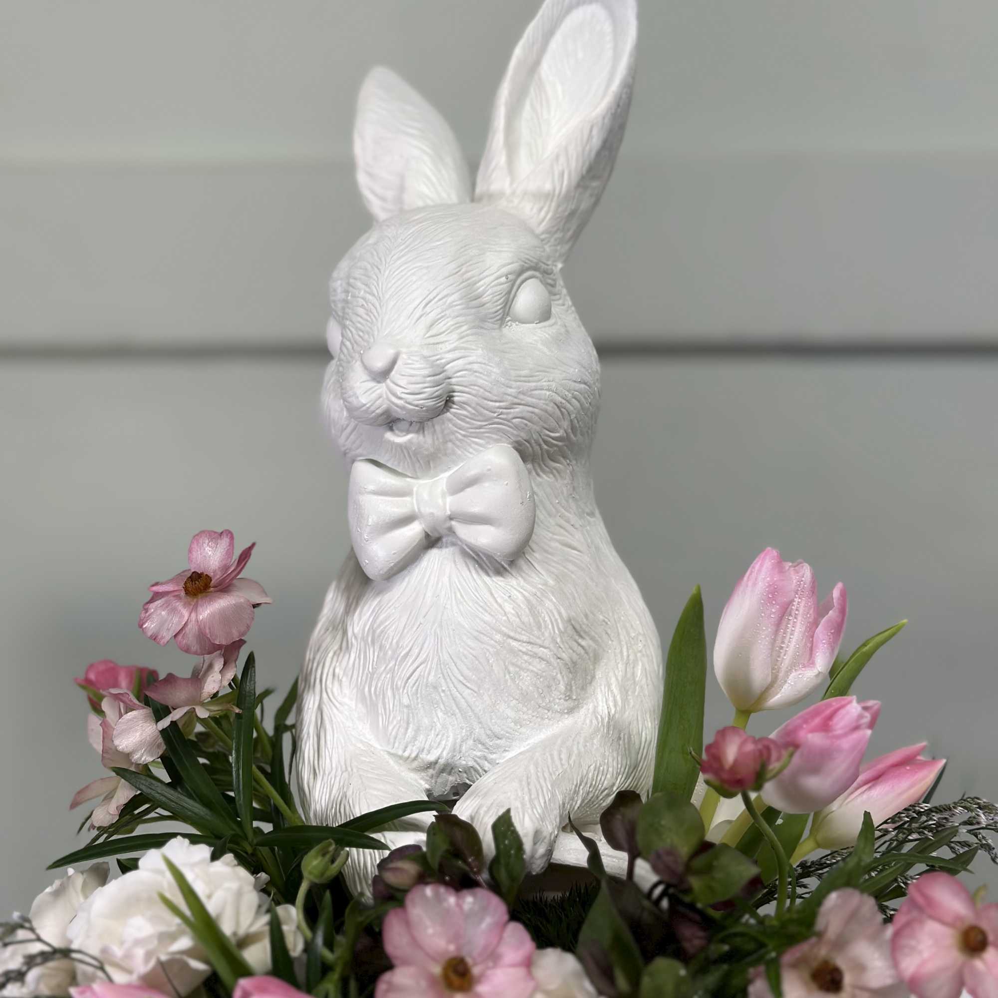 White rabbit figurine surrounded by pink and white flowers