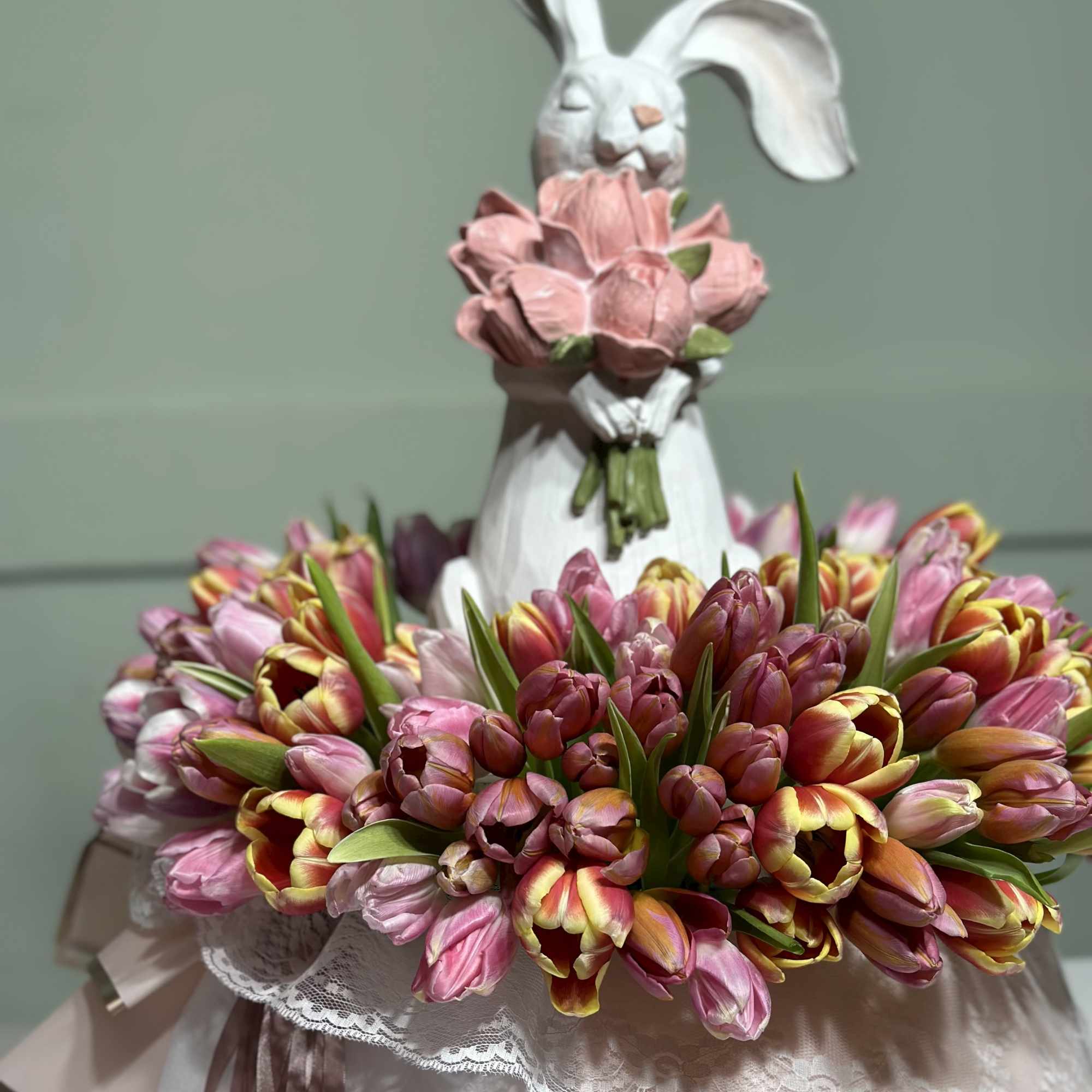 Bouquet of pink and multicolored tulips with a white rabbit figurine