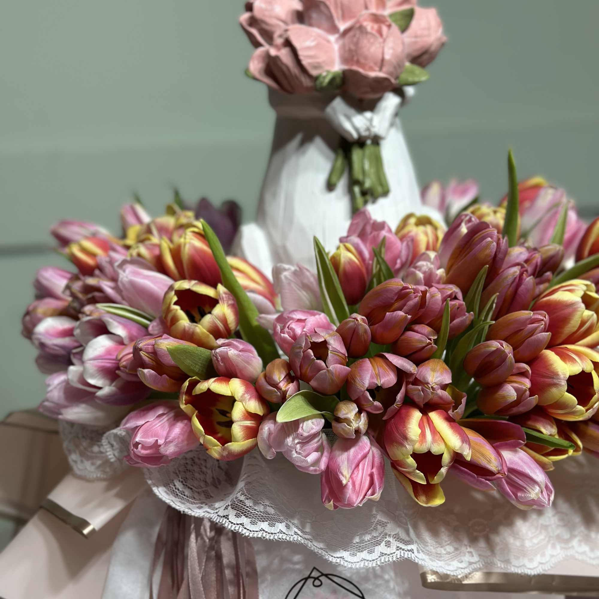 Bouquet of pink and multicolored tulips wrapped in lace and paper
