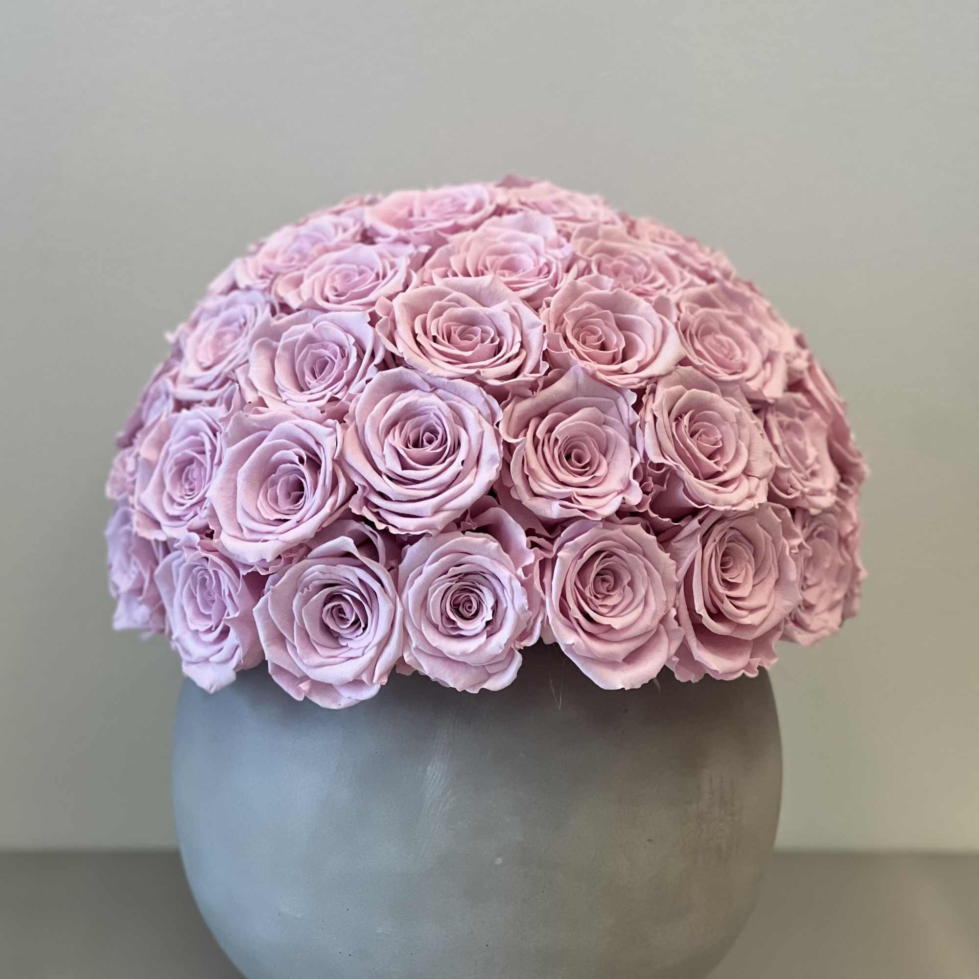 Round bouquet of pink roses in a gray vase