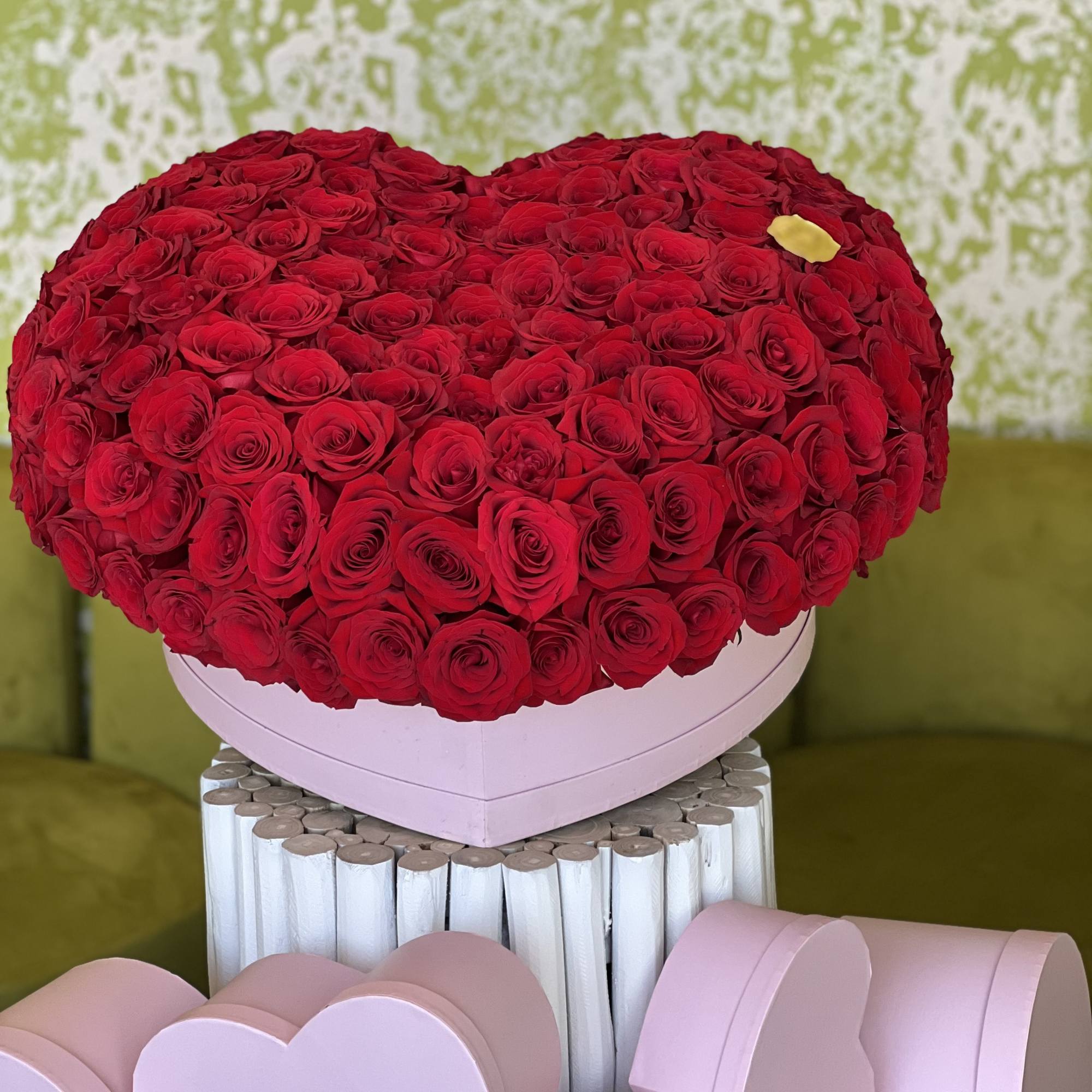 Heart-shaped box of red roses with pink heart boxes below