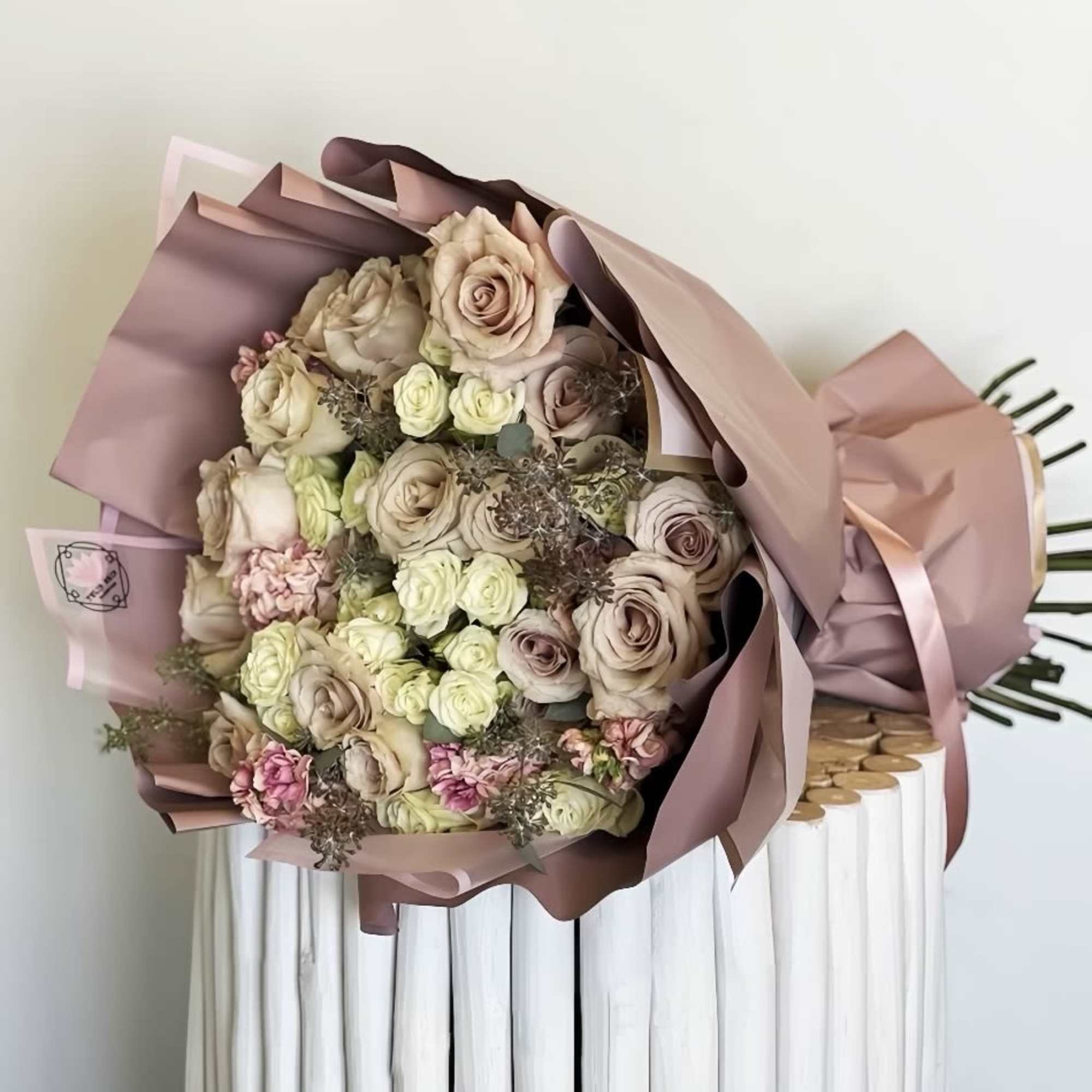 Bouquet of blush and cream roses wrapped in pink paper