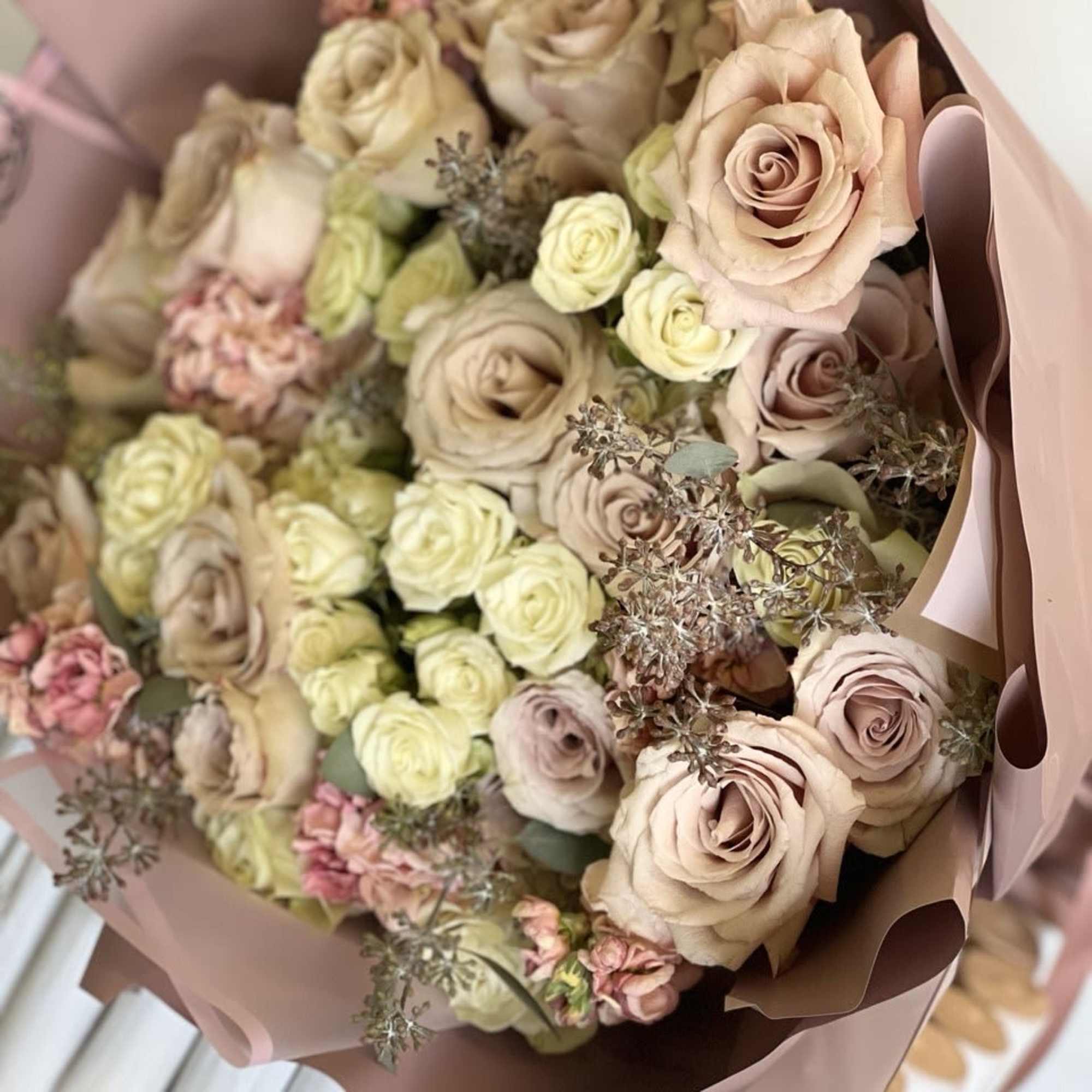 Bouquet of blush and cream roses wrapped in pink paper, photo 2 of 2