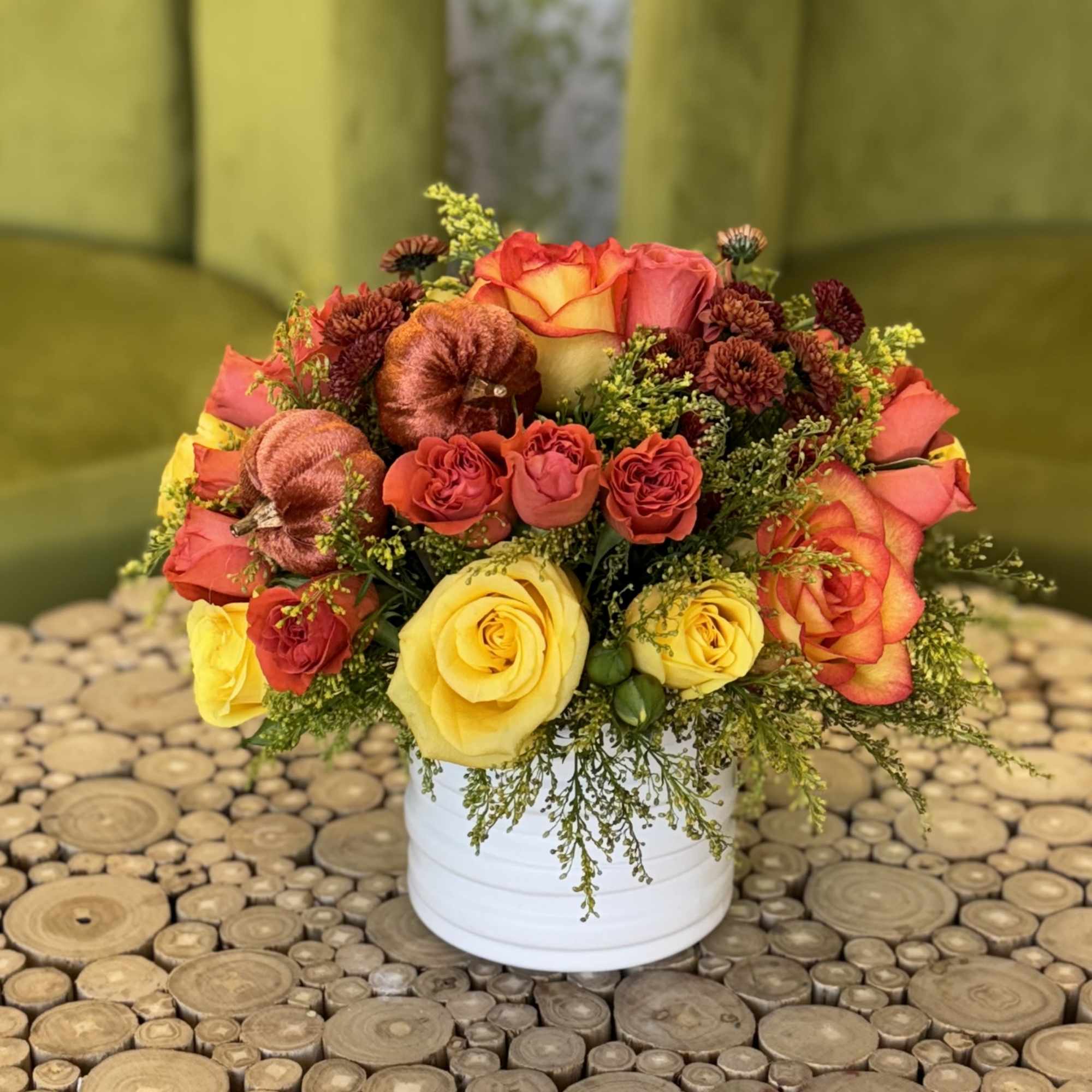 Bouquet of yellow and orange roses in a white container