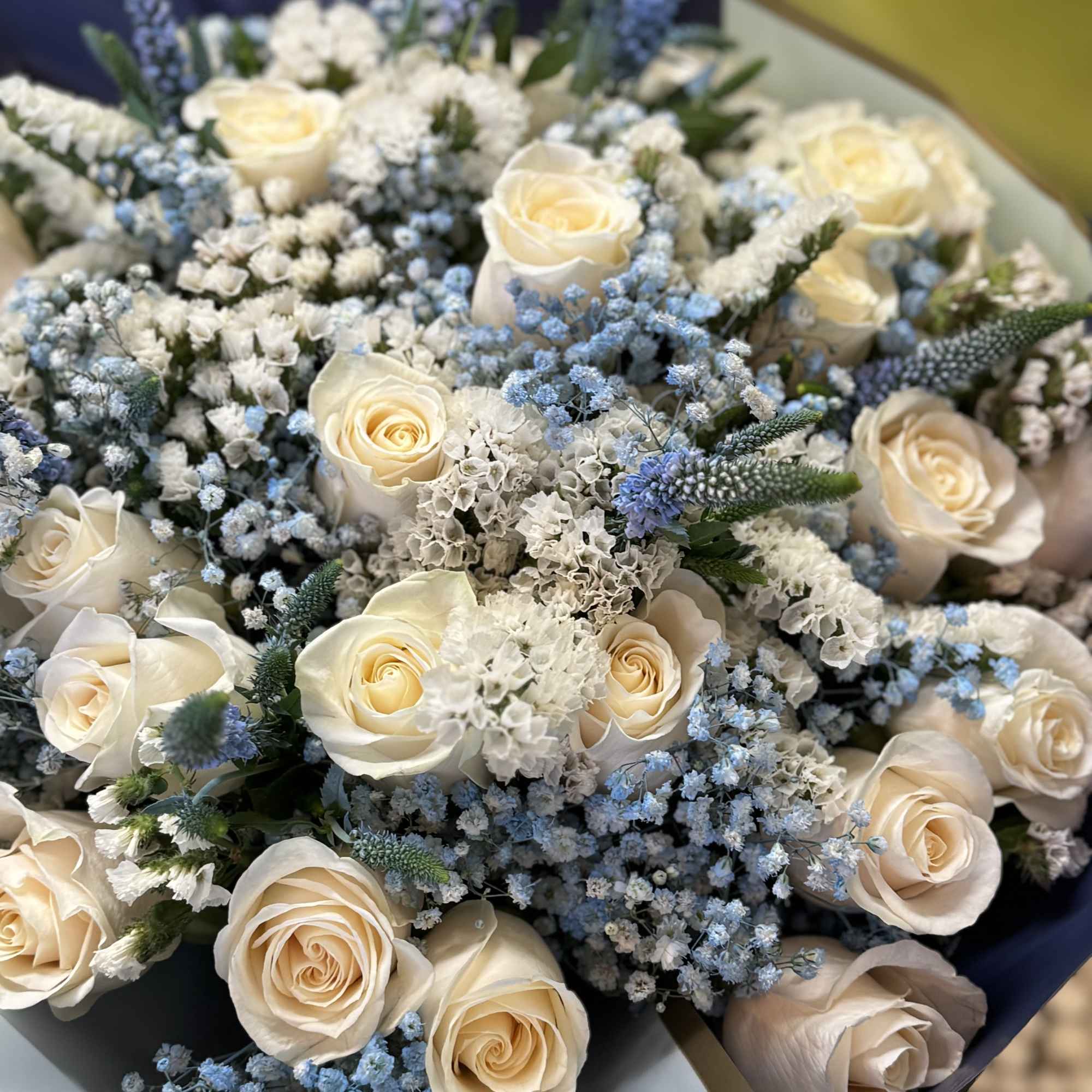 Bouquet of cream roses with blue and white filler flowers