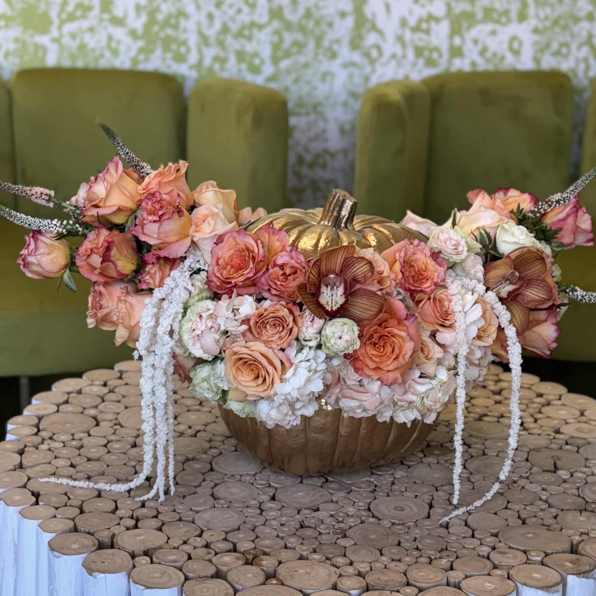 Peach and pink floral arrangement in a gold pumpkin vase