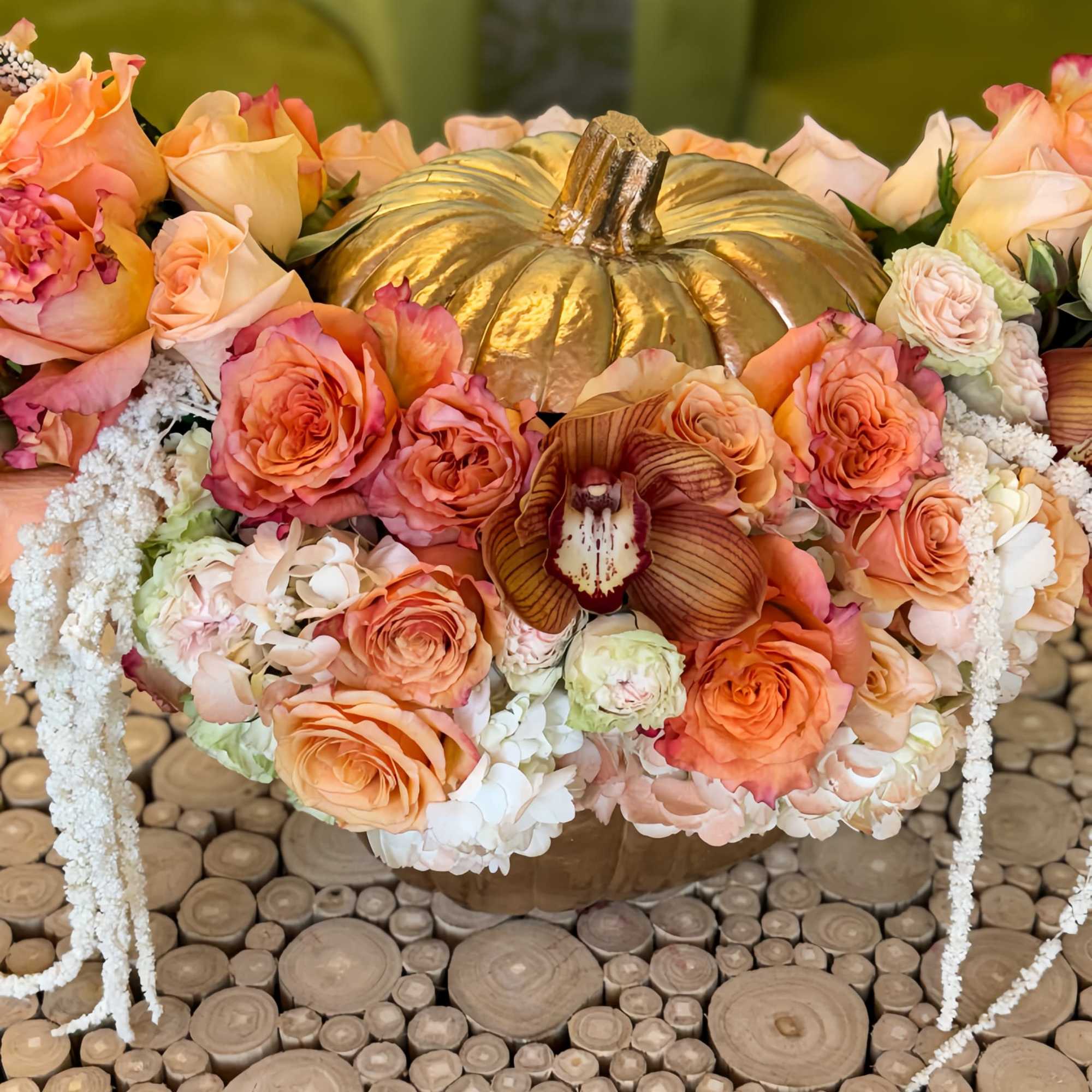 Peach rose arrangement around a gold pumpkin centerpiece