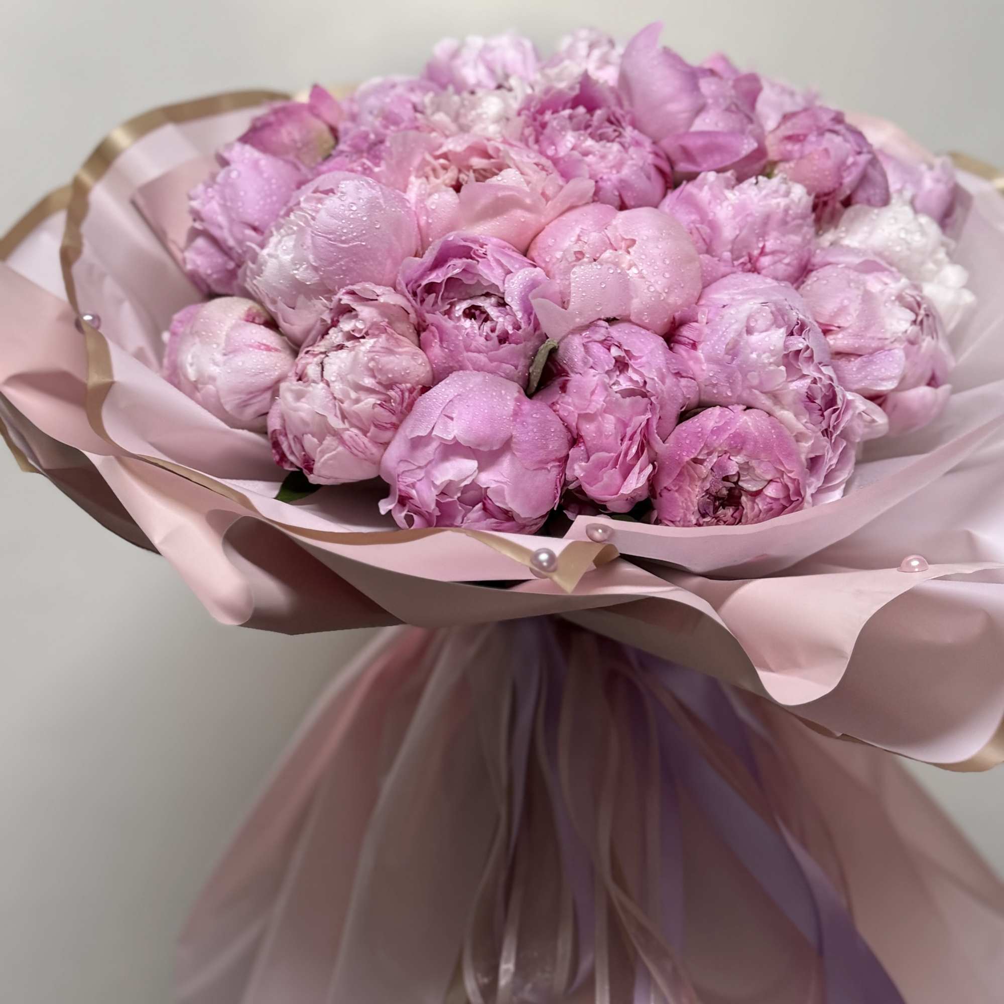 Pink peony bouquet wrapped in pale pink paper with ribbon