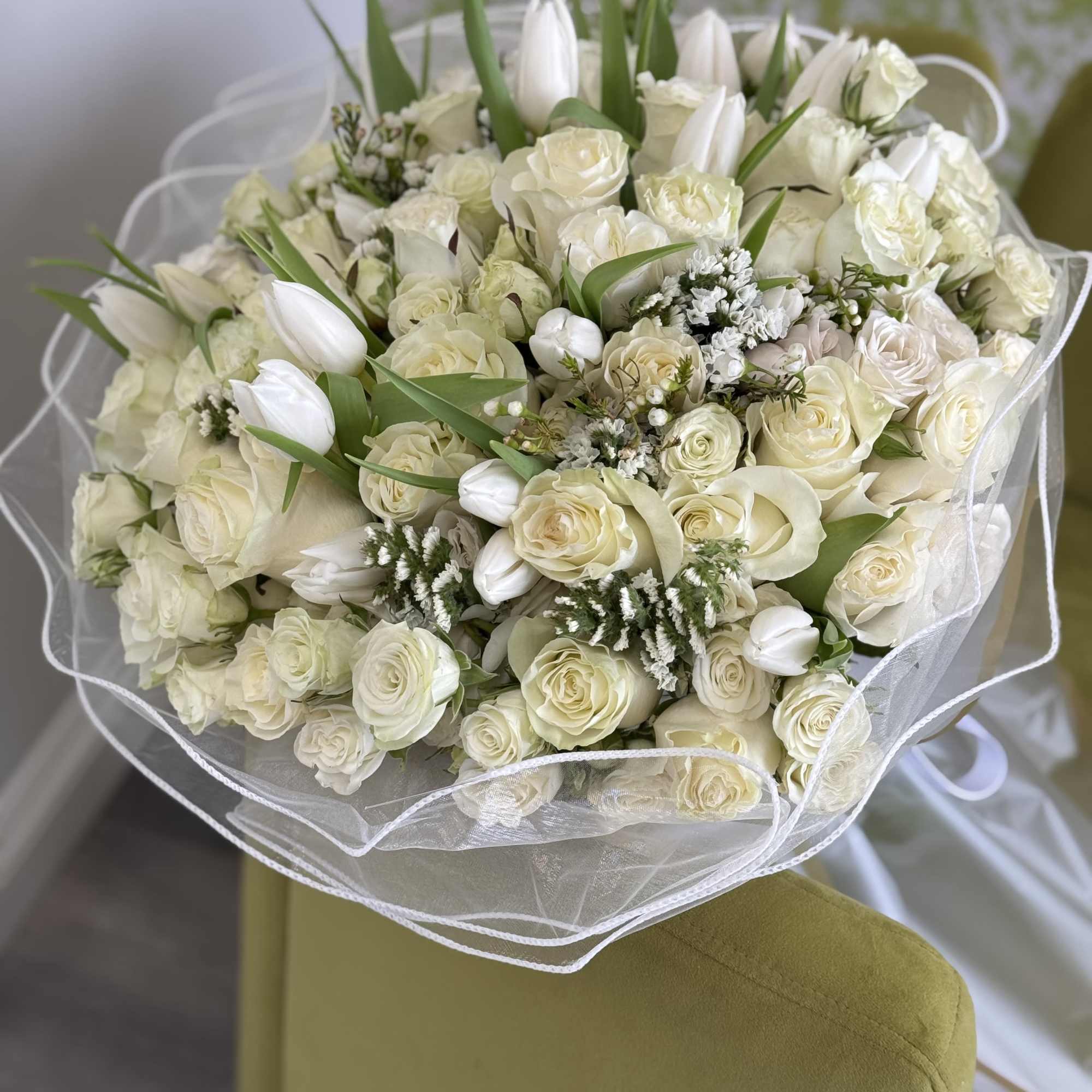 White rose and tulip bouquet wrapped in sheer white paper