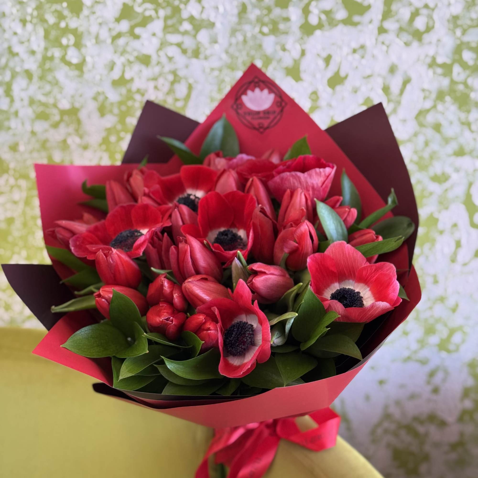 Bouquet of red anemones wrapped in pink and burgundy paper