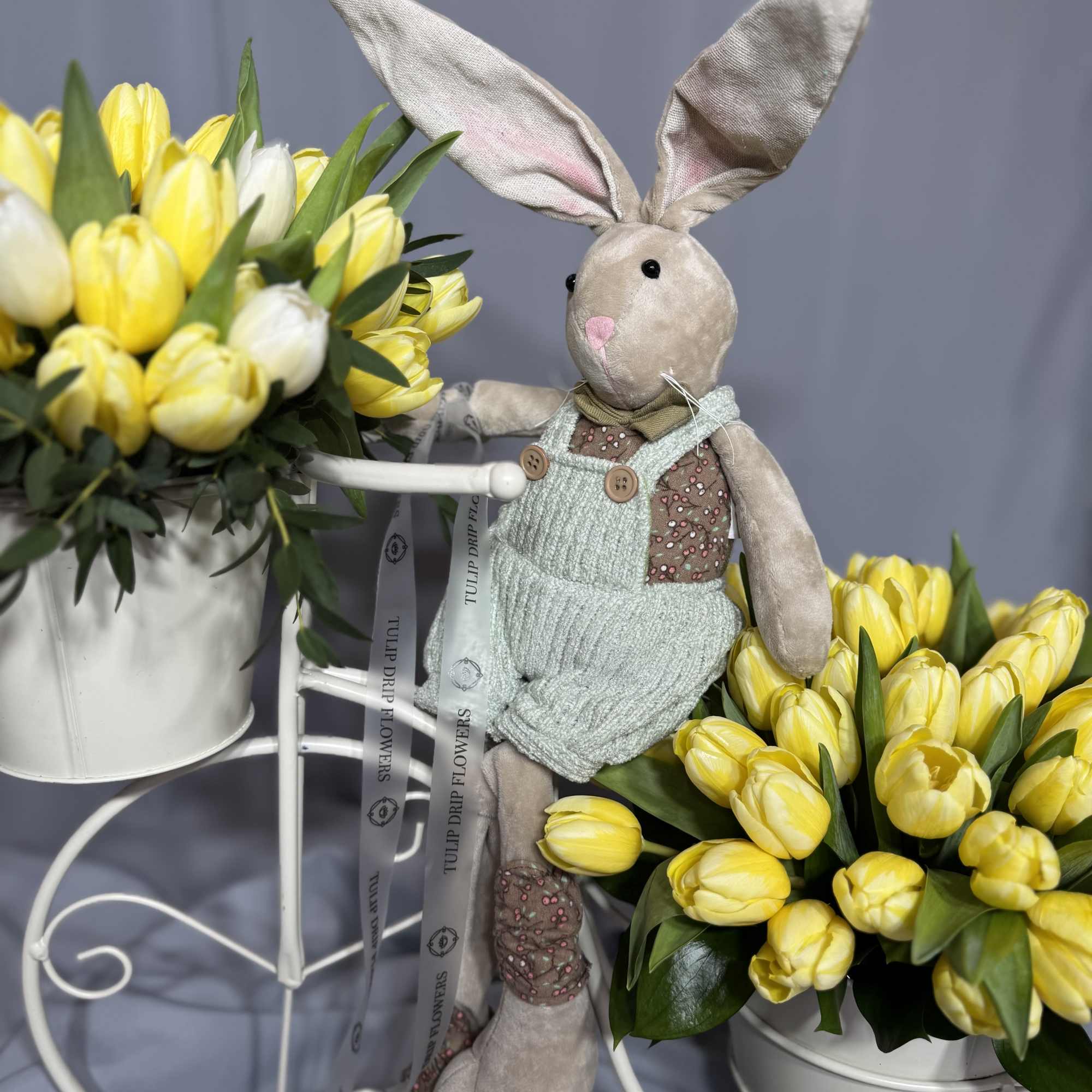 Yellow tulip arrangements with a plush bunny in the center