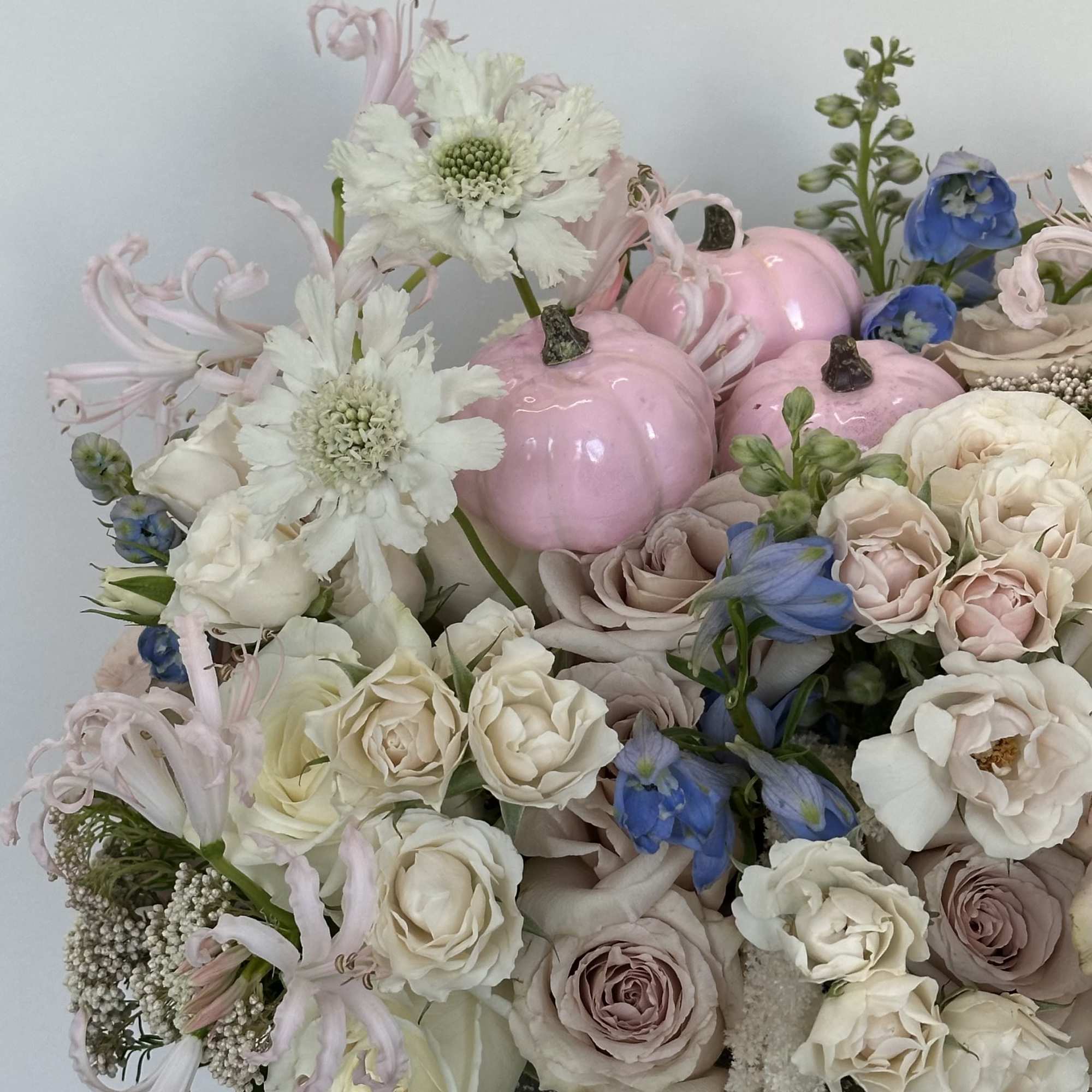 Bouquet of pale roses and white flowers with pink pumpkins