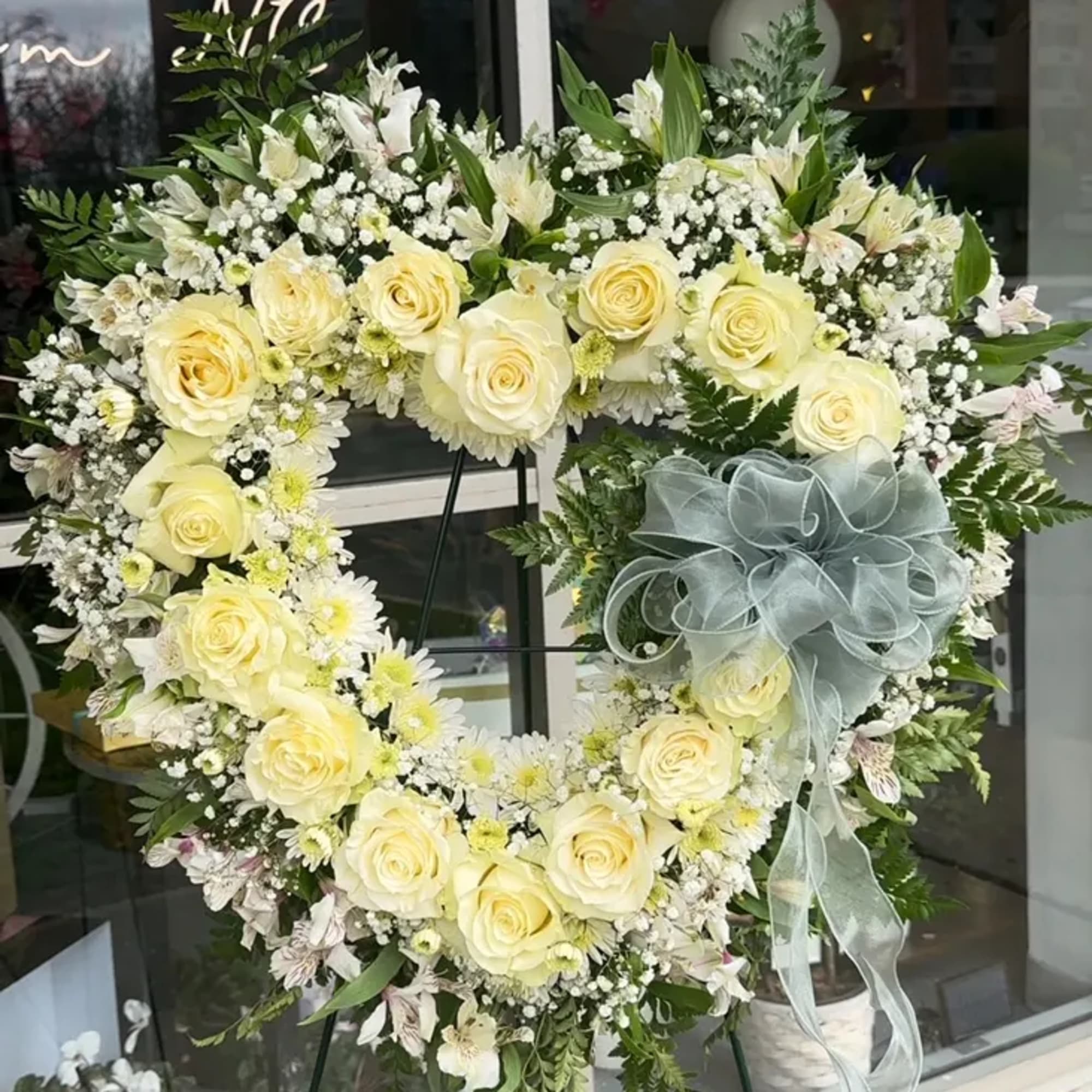 Our floral heart spray features a beautiful arrangement of white roses and