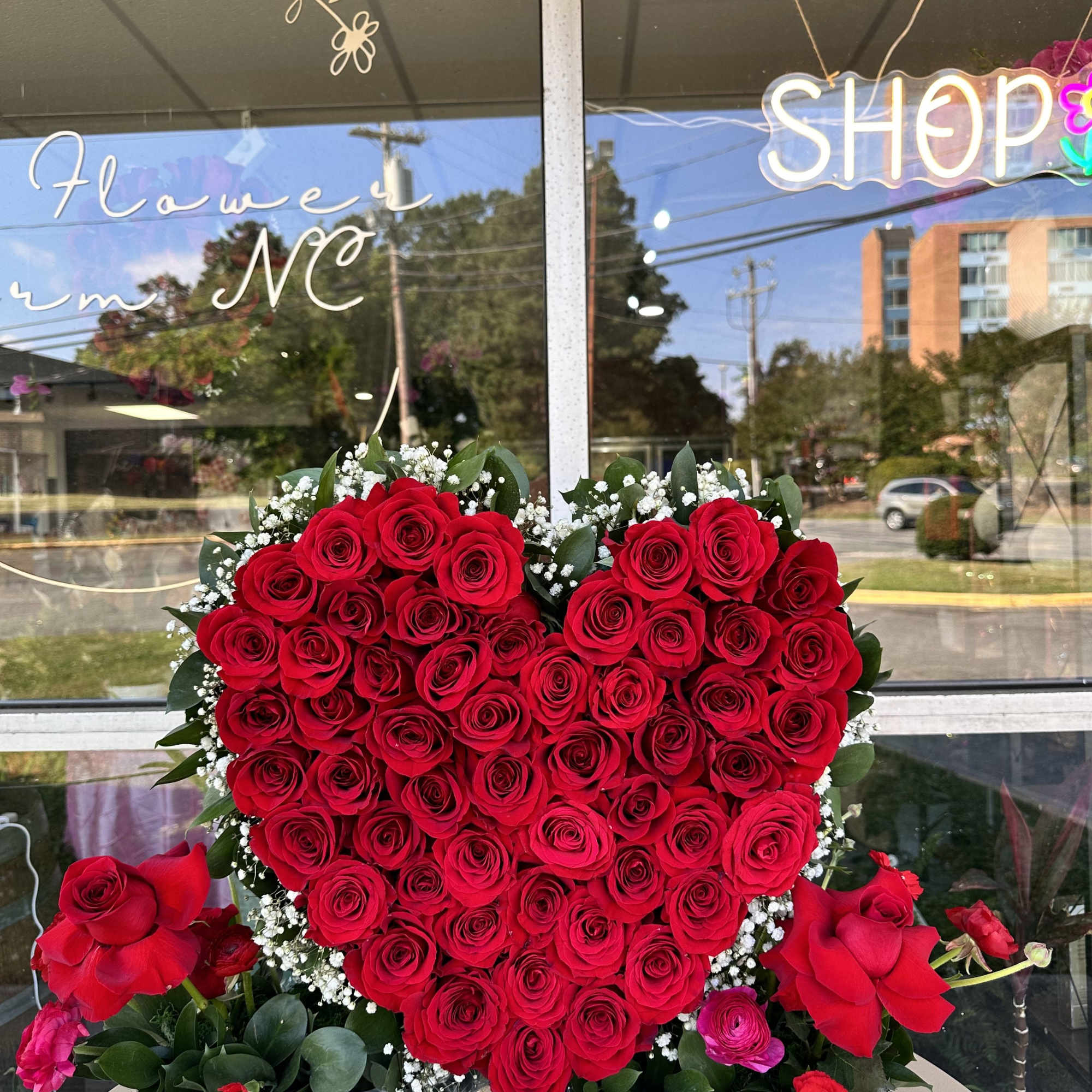 Heart-shaped red rose arrangement in a white box