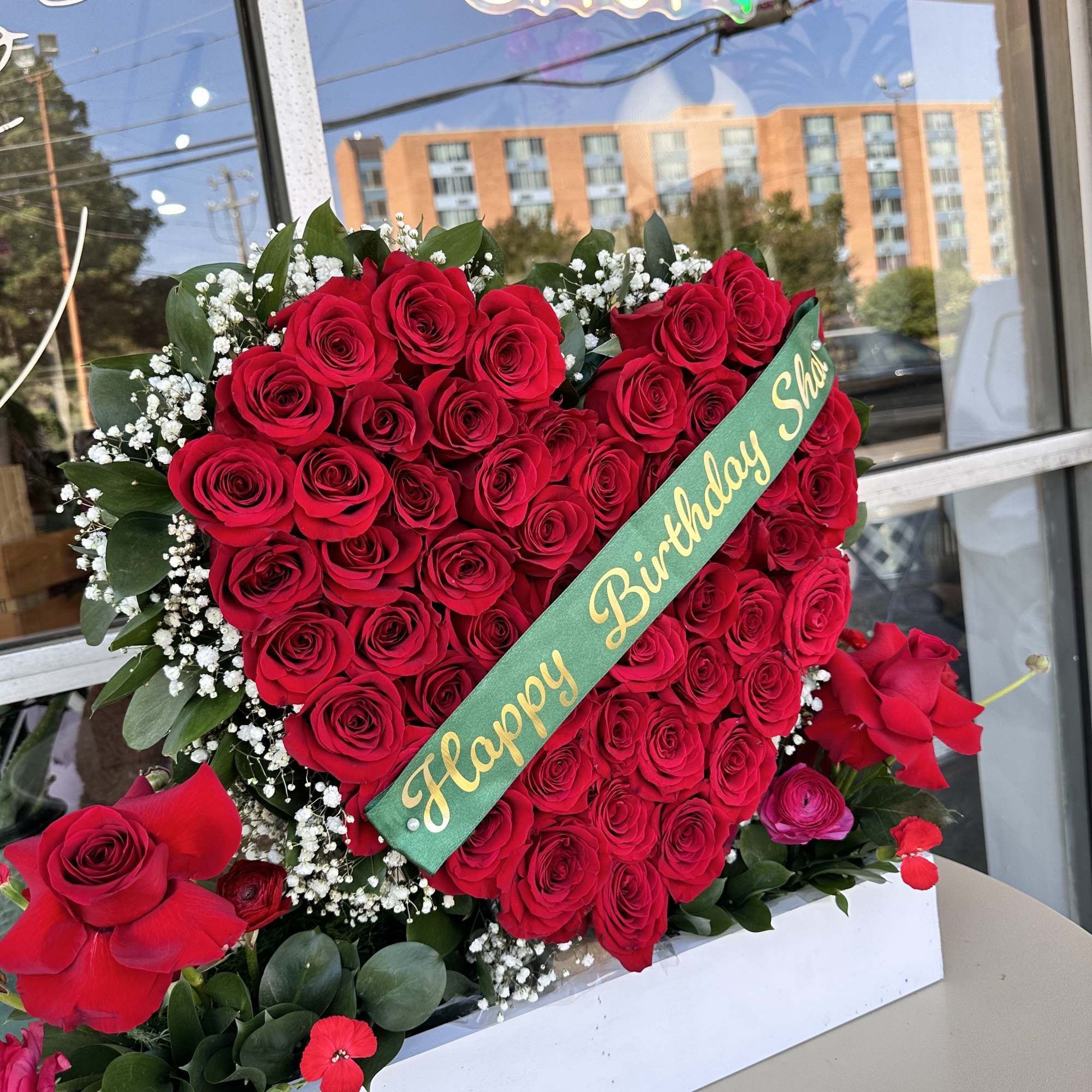Heart-shaped red rose arrangement with a birthday sash