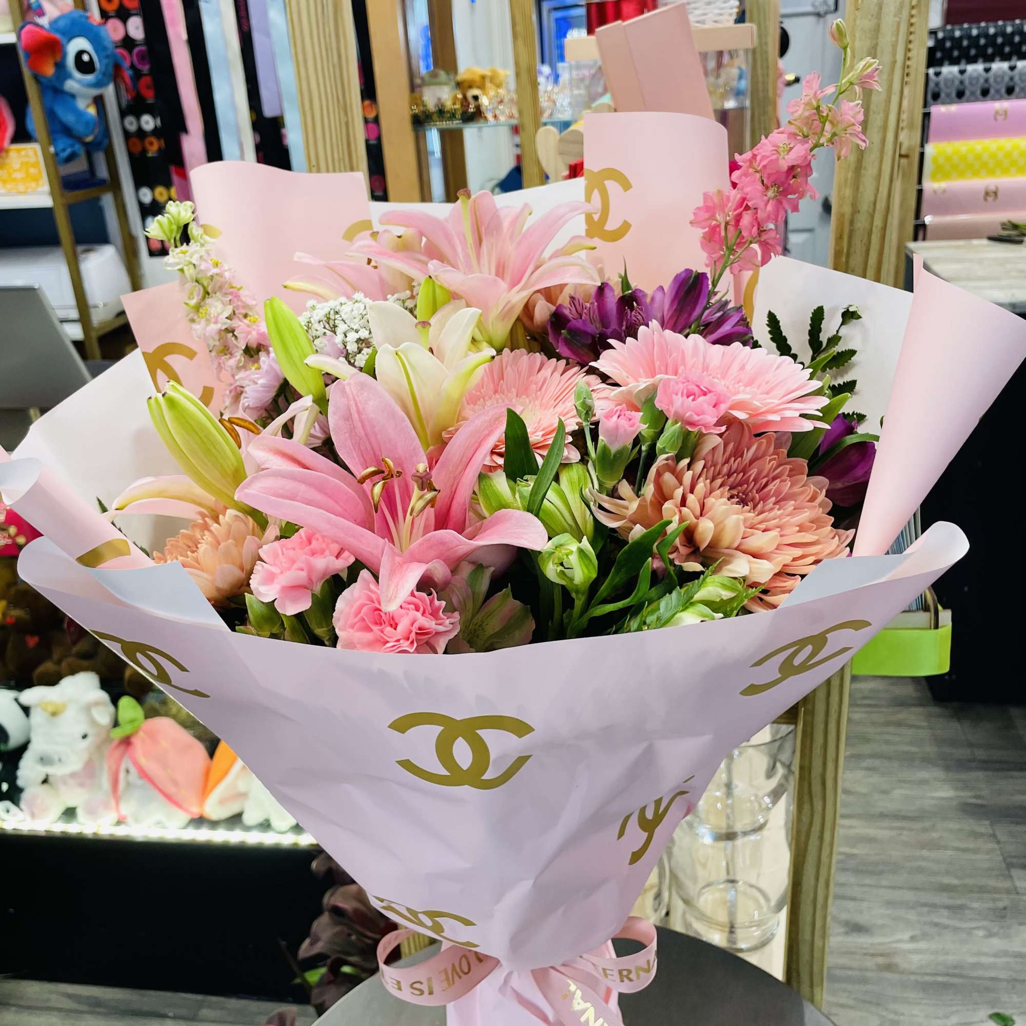Pink and purple mixed bouquet wrapped in pale pink paper