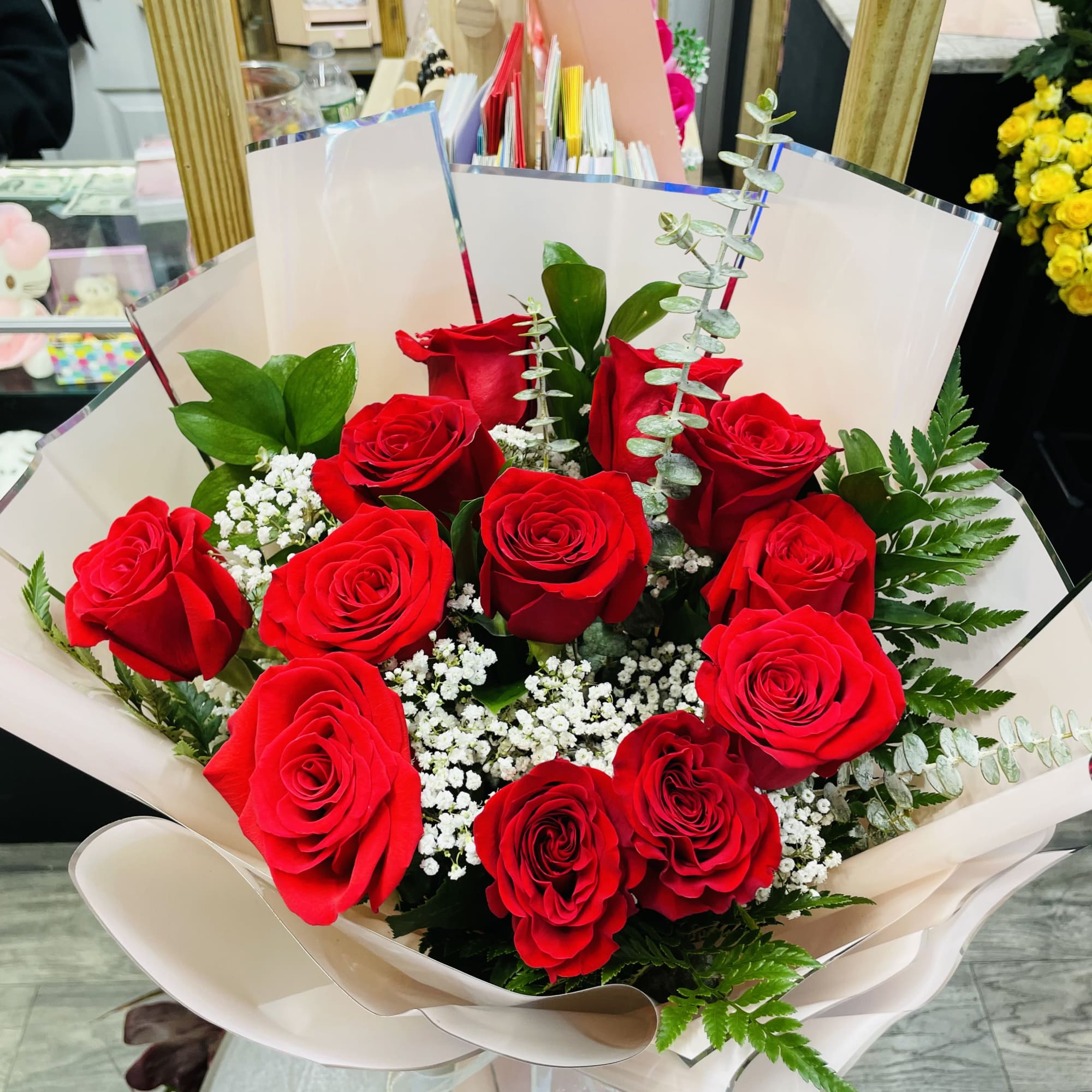 Bouquet of red roses with baby's breath in pale wrapping