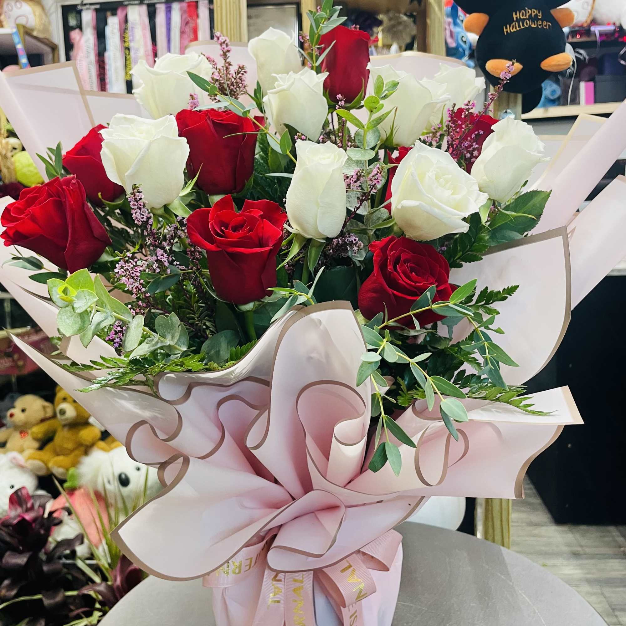 Bouquet of red and white roses wrapped in pink paper