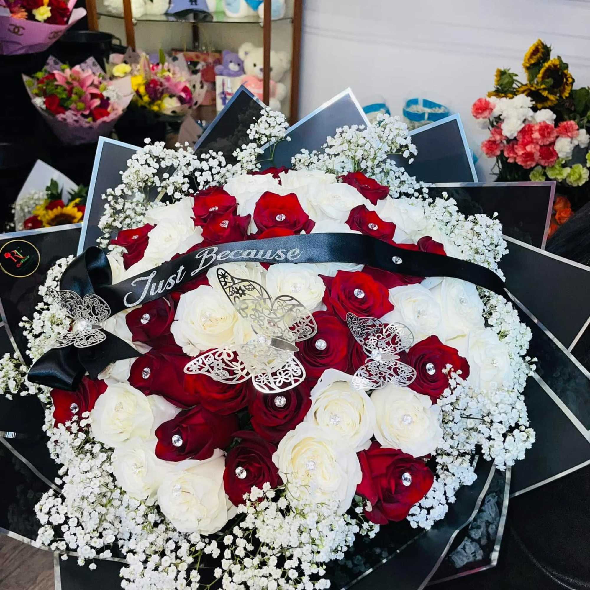 Red and white rose bouquet with baby's breath and a black ribbon