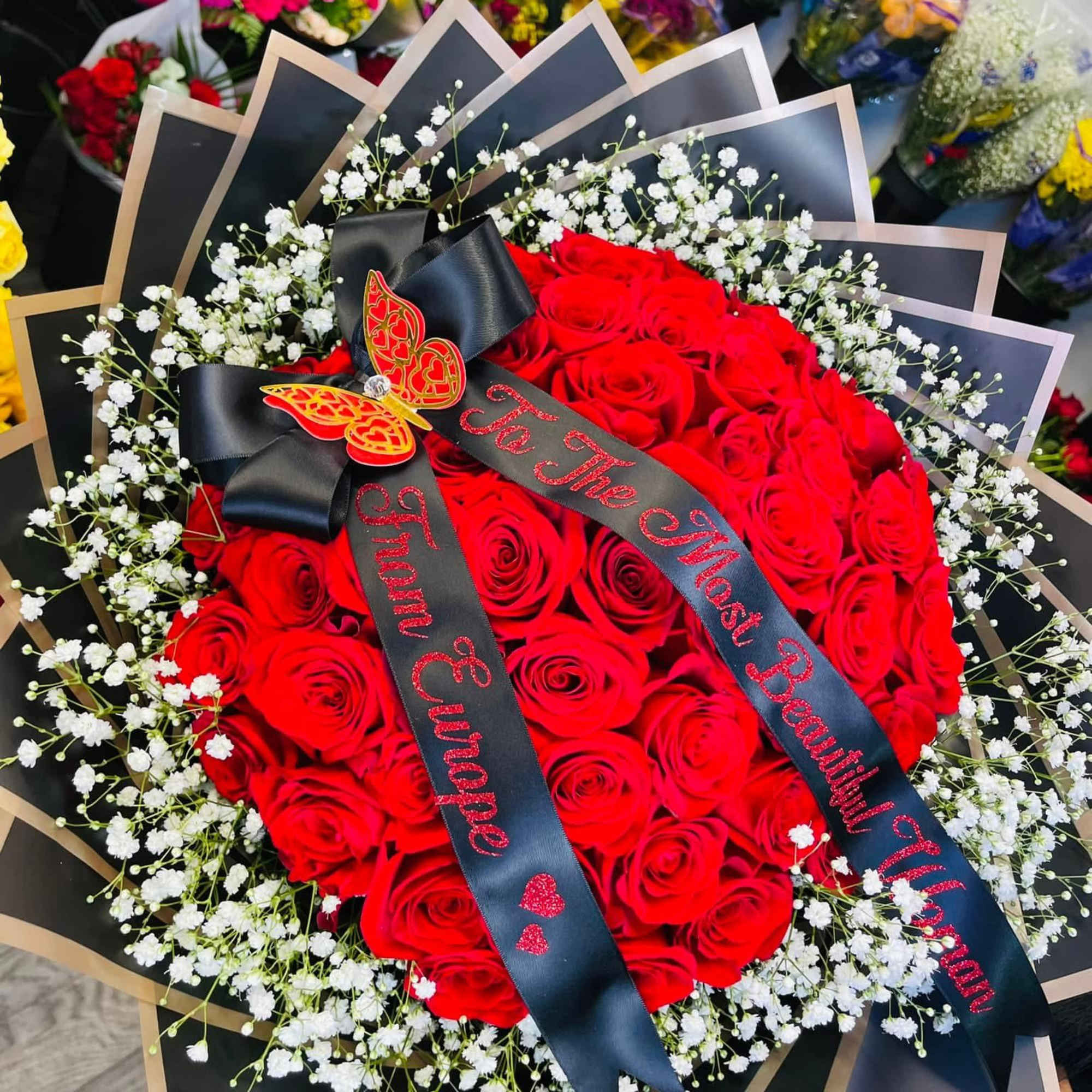 Red rose bouquet with baby's breath and black ribbons