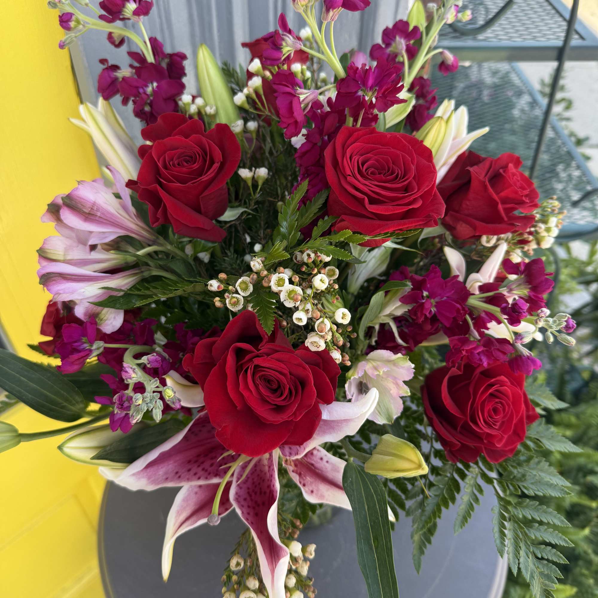 Bouquet of red roses and pink lilies with magenta filler flowers