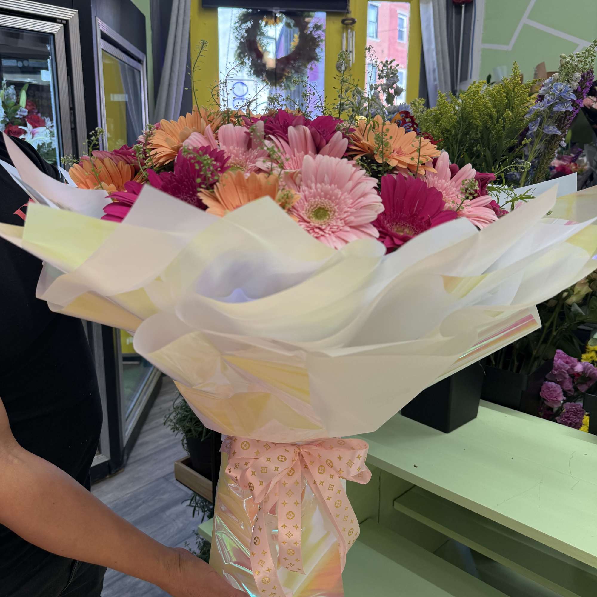 Bouquet of pink and orange gerbera daisies wrapped in white paper
