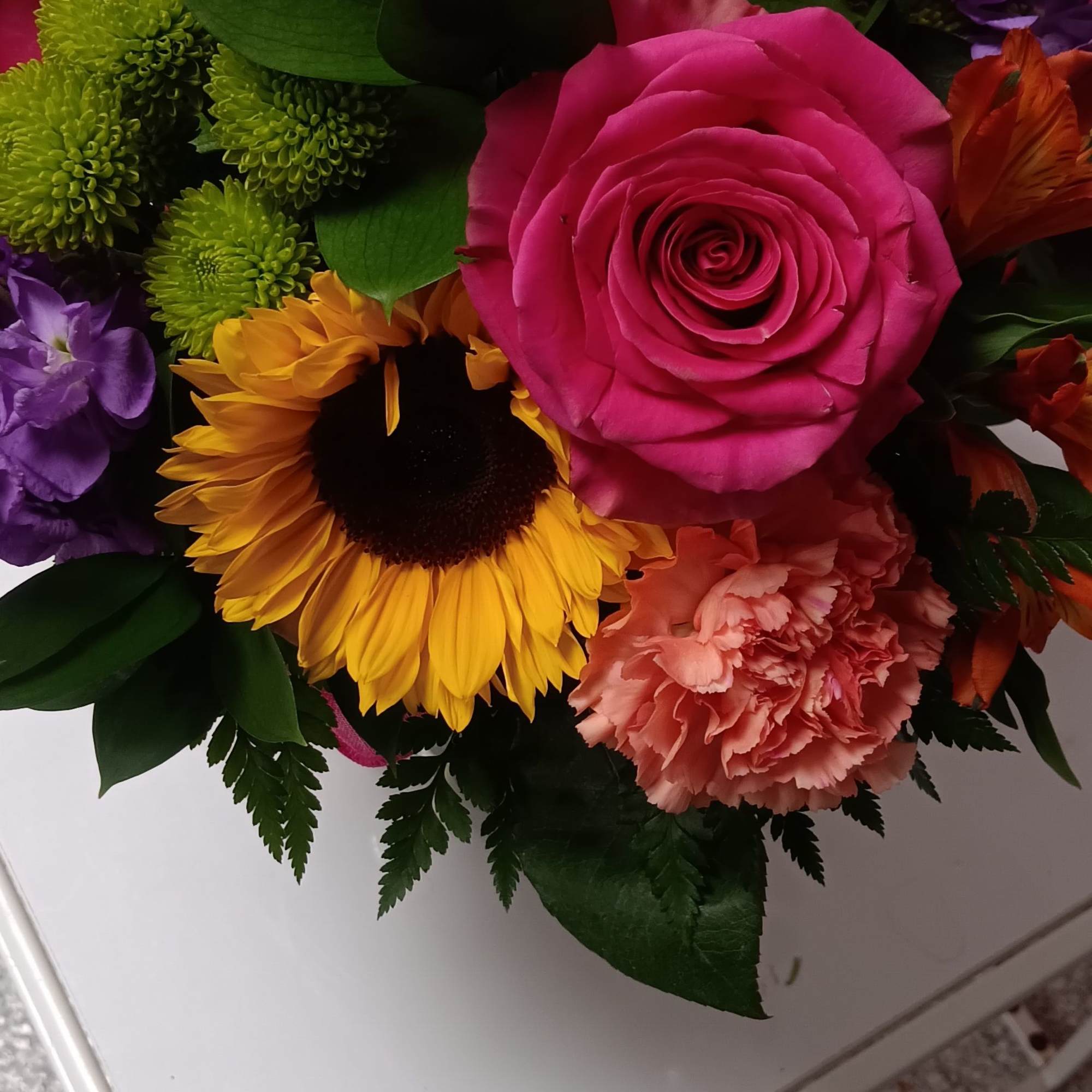 Bright mixed bouquet with a pink rose and sunflowers