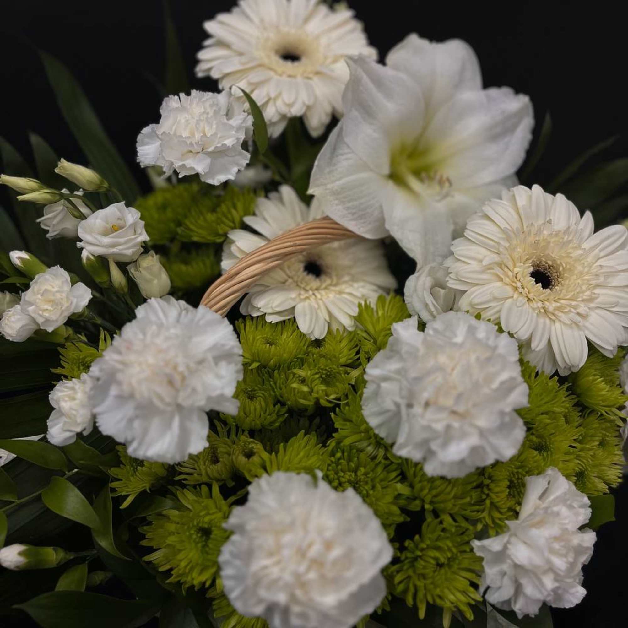 White gerbera daisies and carnations in a bouquet with green accents