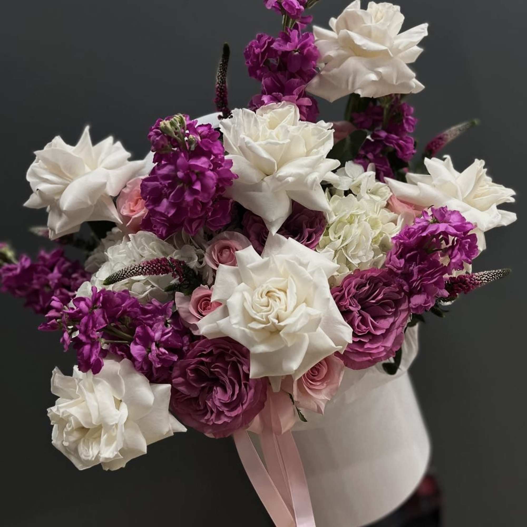 Bouquet of white and magenta flowers with pink roses in a white vase
