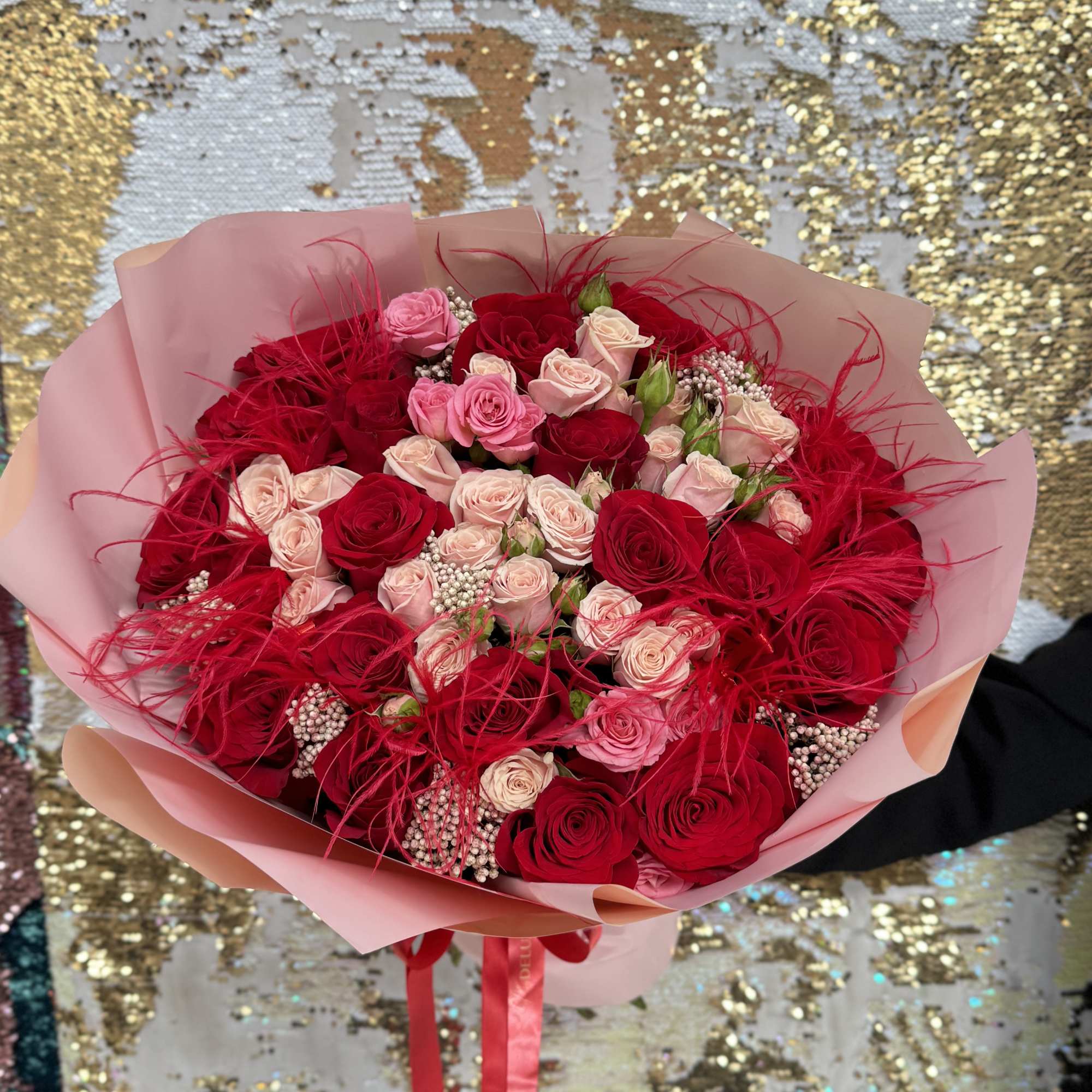 Bouquet of red and pink roses wrapped in pink paper