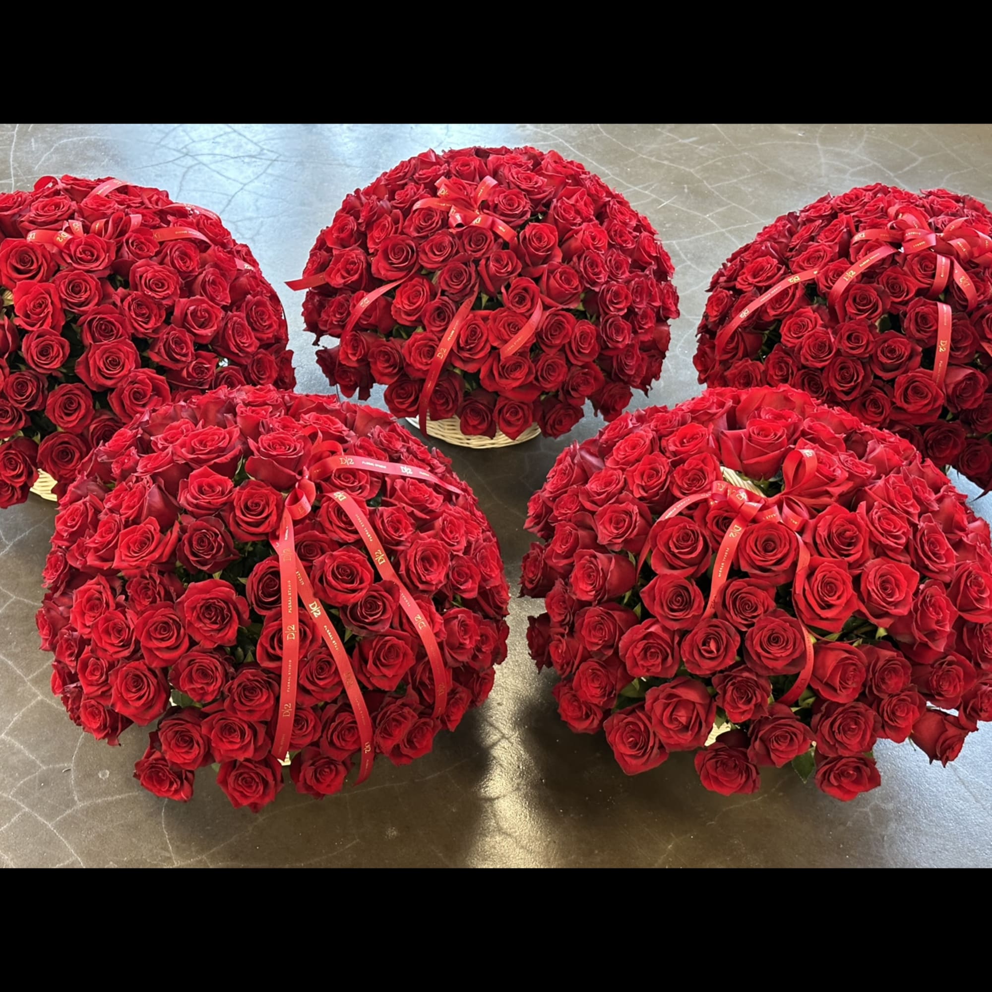 Five dome-shaped bouquets of red roses with ribbon accents