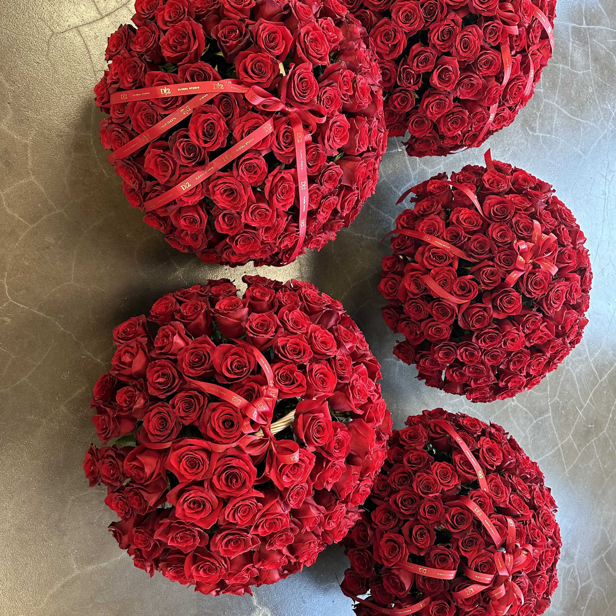 Five round bouquets of red roses tied with red ribbons