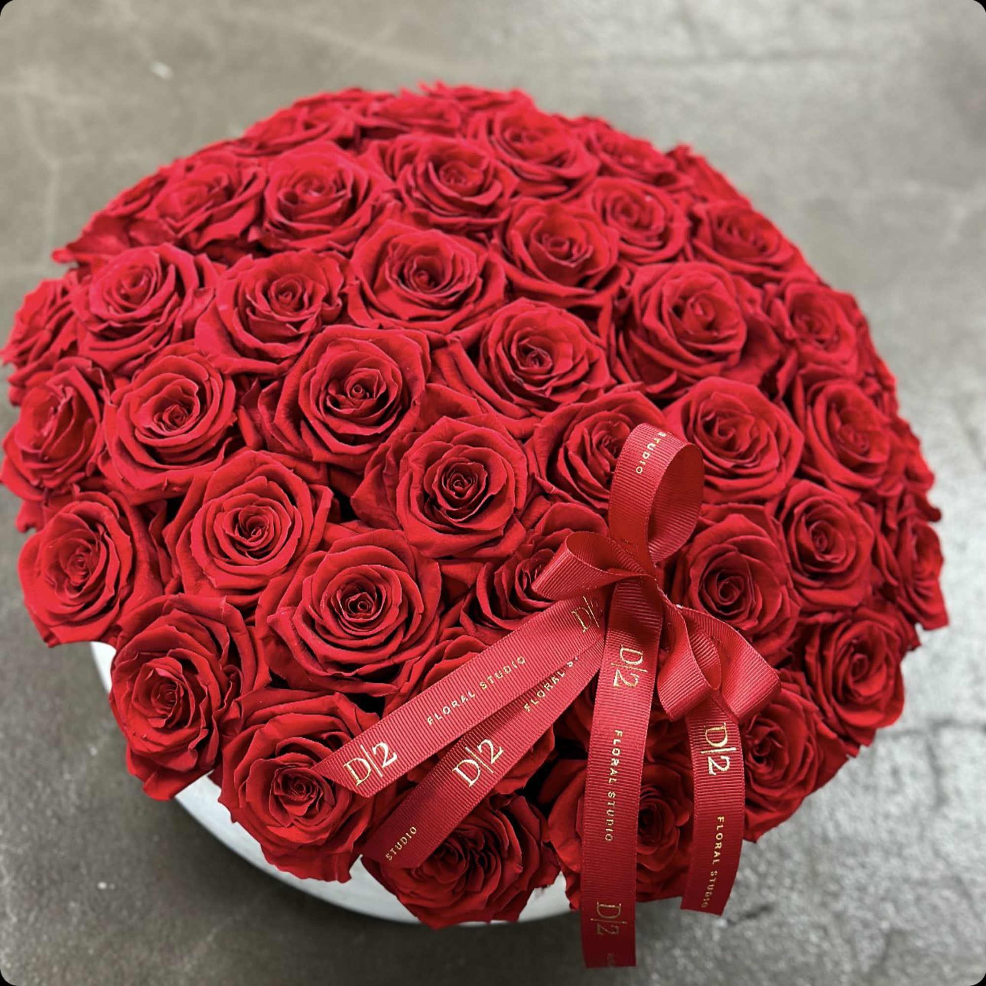 Round bouquet of red roses with a red ribbon bow