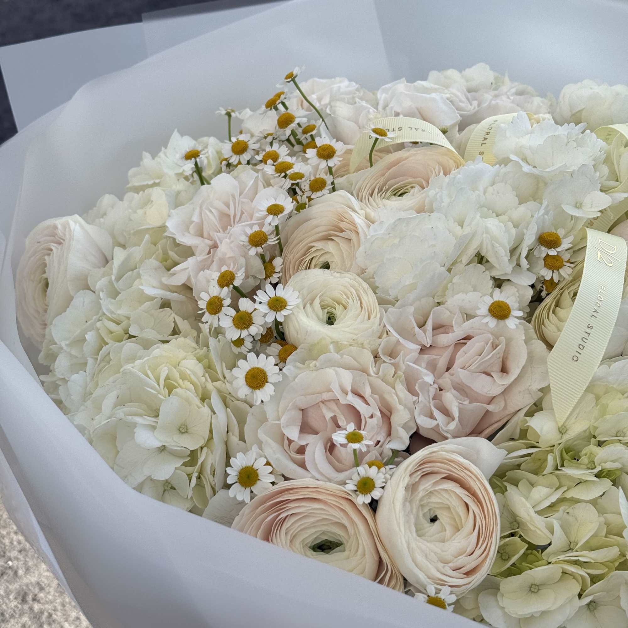 Bouquet of white and blush flowers wrapped in white paper